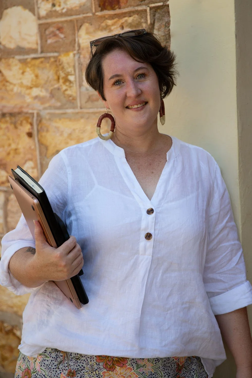 Conni Warren holding documents and laptop, representing recruitment coordination and job design expertise