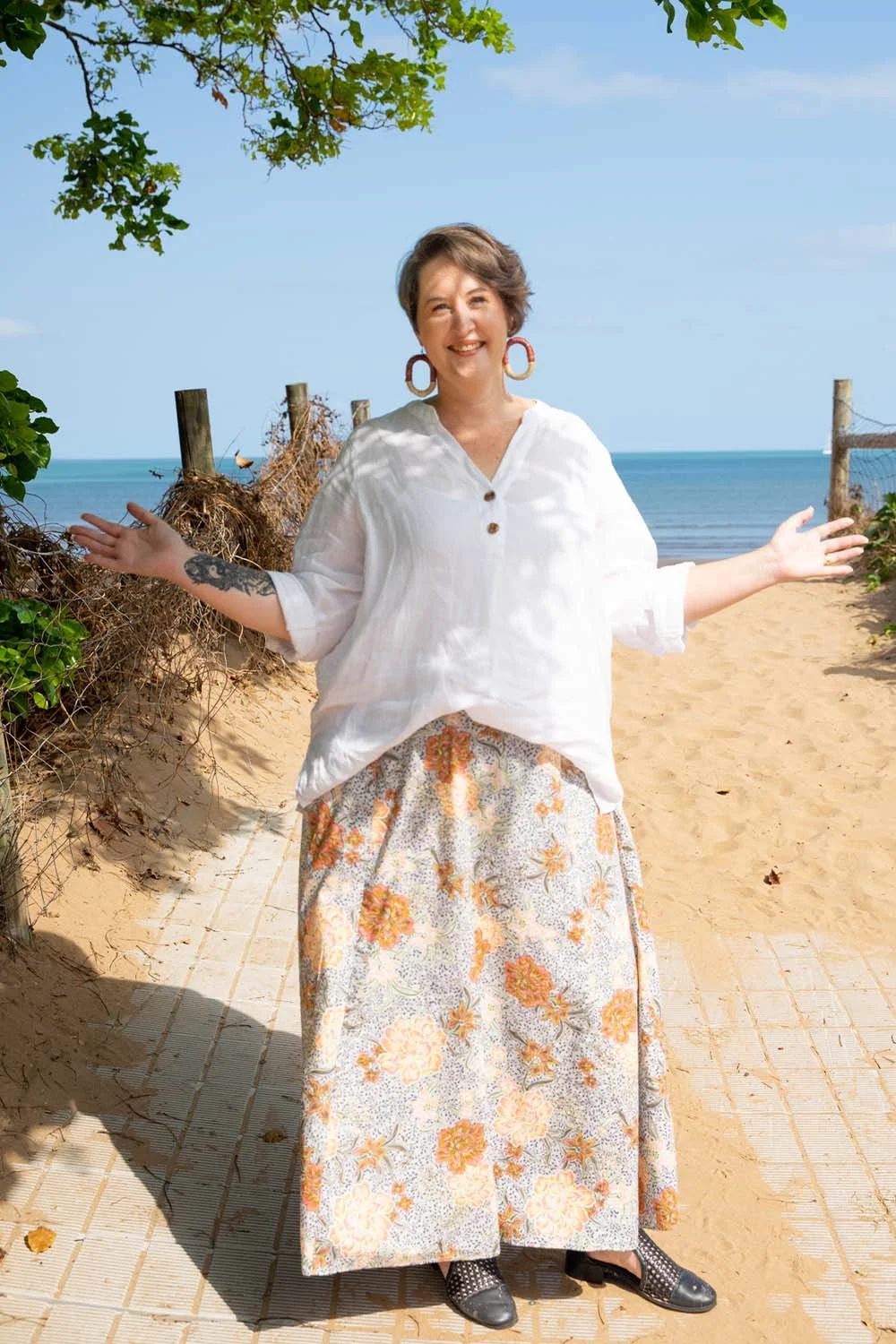 Conni Warren standing on a Northern Territory beach, smiling and welcoming, representing approachable leadership