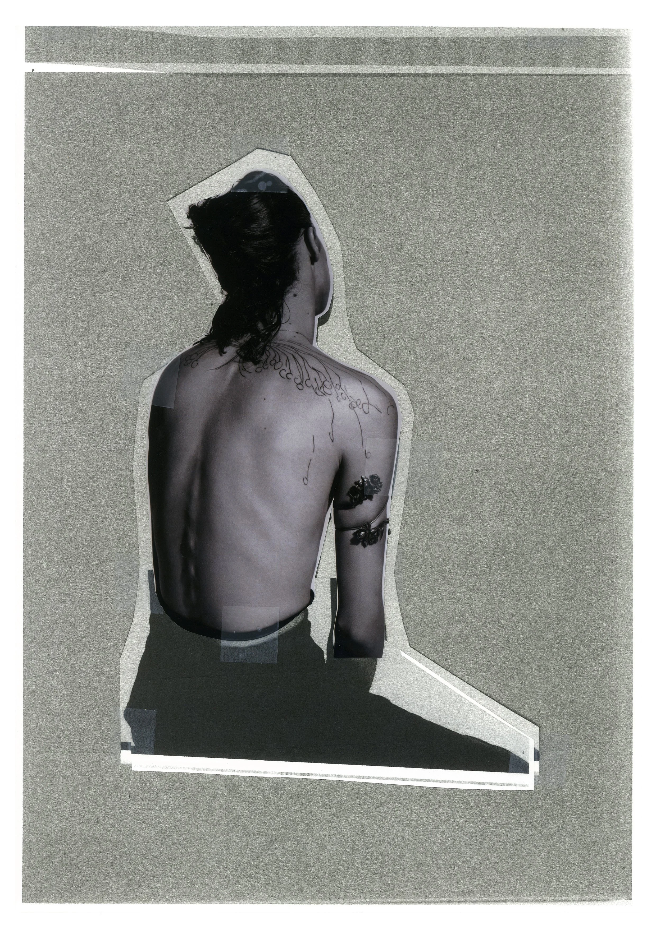 Black and white cutout of a person with long hair, viewed from the back, showing tattoos on their shoulder and arm, placed on a gray background.