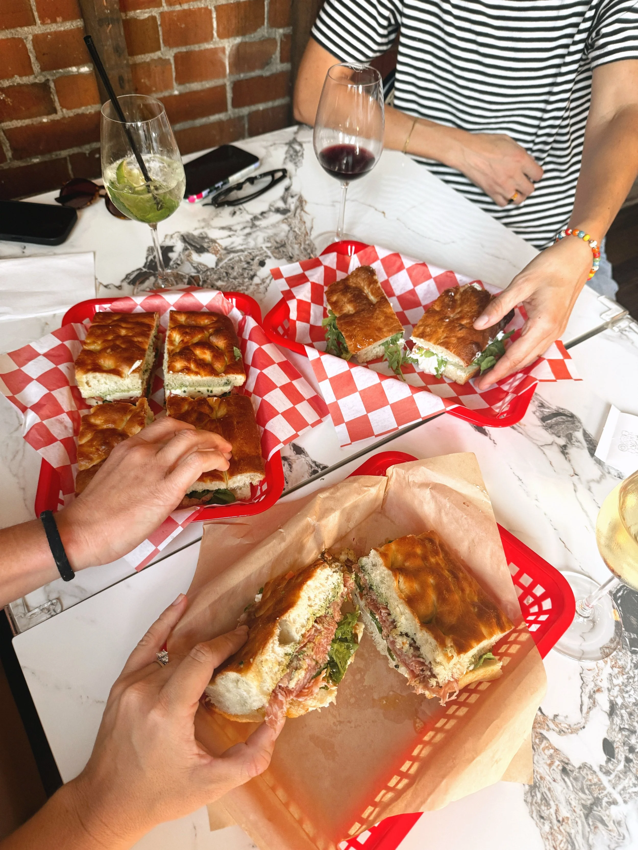 Wine, spritzes, and sandwiches during a Friday happy hour in late September @paninodivinokc on @w39thkc. 

I was instantly amused by the wine window off the side patio and the flatbreads being made fresh when we entered. 

I ordered a glass of Chardo