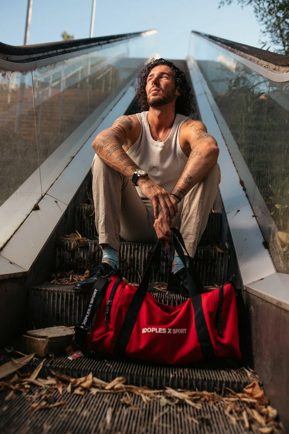 Portrait photo mode d'un homme tatoué assis sur un escalator par François Mougel photographe à Nantes