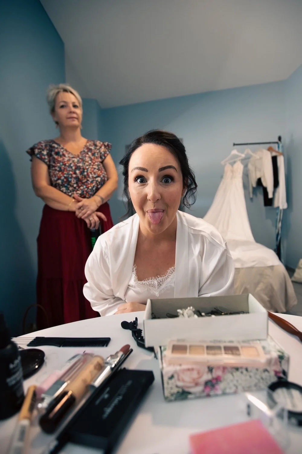 La mariée s'amuse et fait une grimace lors de son maquillage.