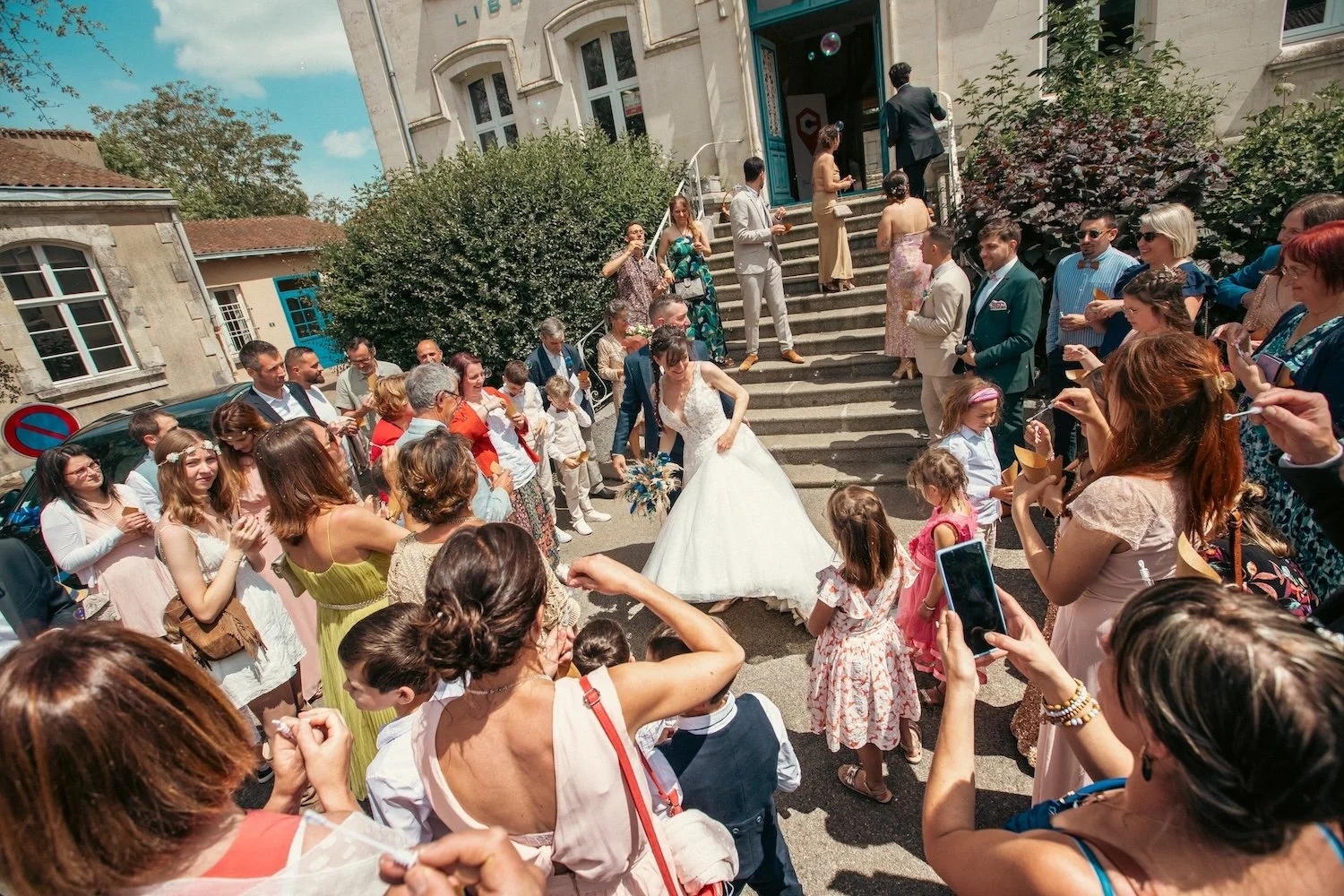 Les mariés sortent sur le parvis de la mairie sous les acclamations des invités.