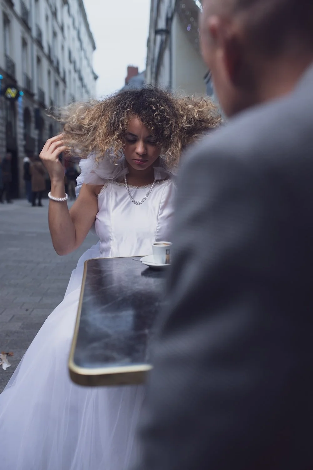Mariée aux cheveux bouclés se coiffant en terrasse à Nantes, vue immersive et authentique.