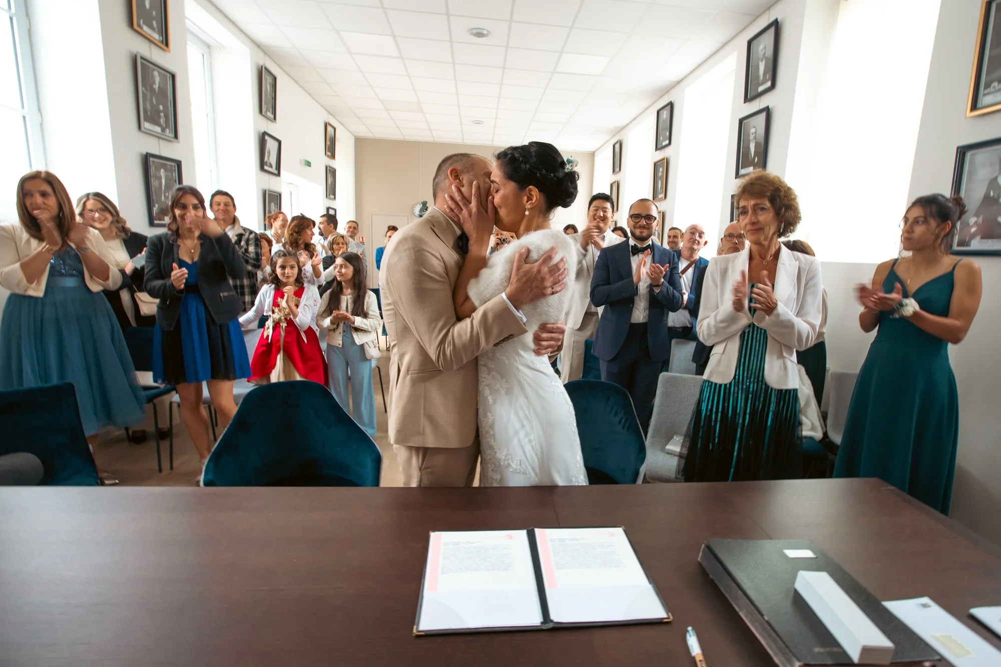 les mariés s'embrassent devant leurs invités à la mairie