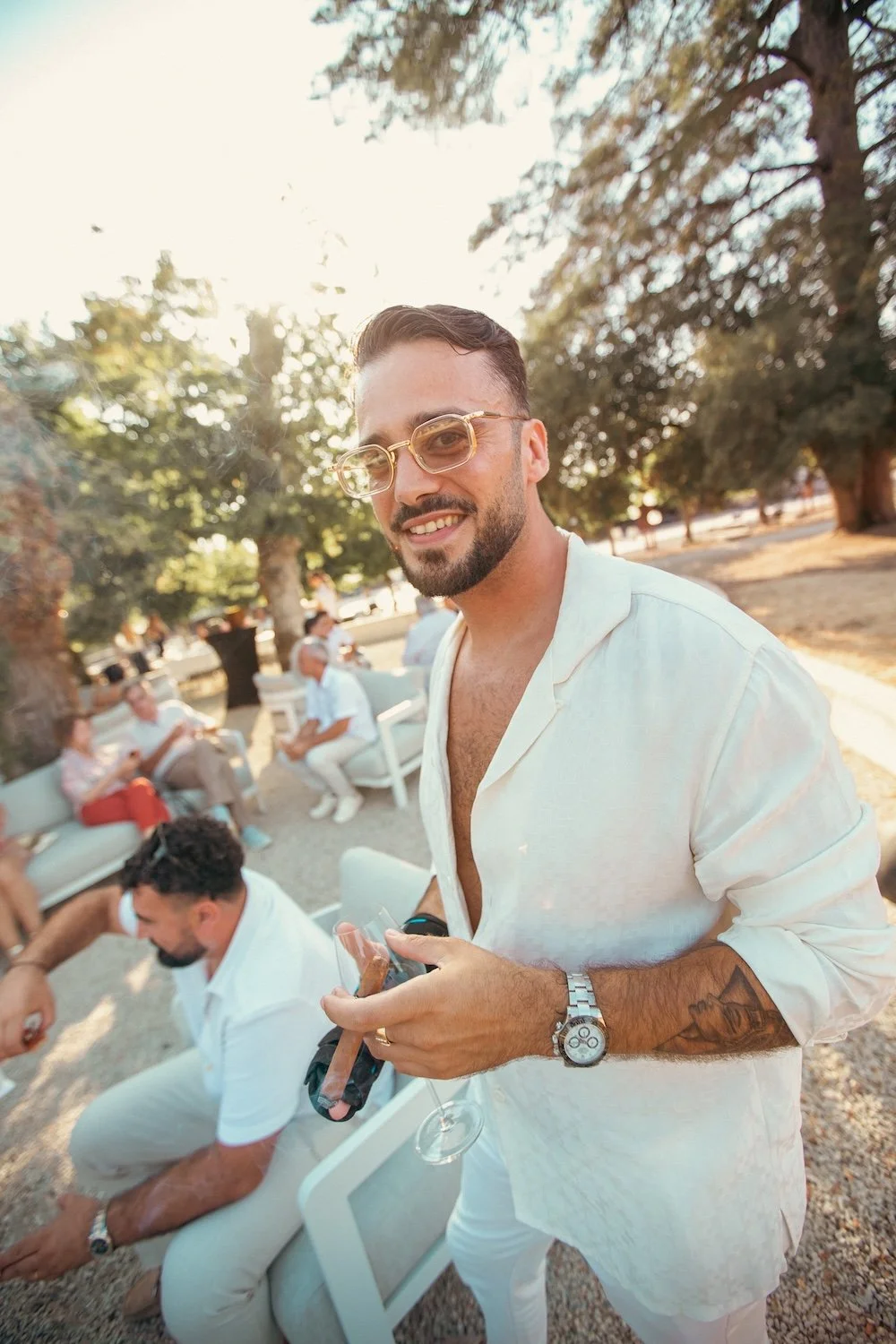 Un jeune homme souriant lors du vin d'honneur dans les jardins du Chateau de Maubreuil.