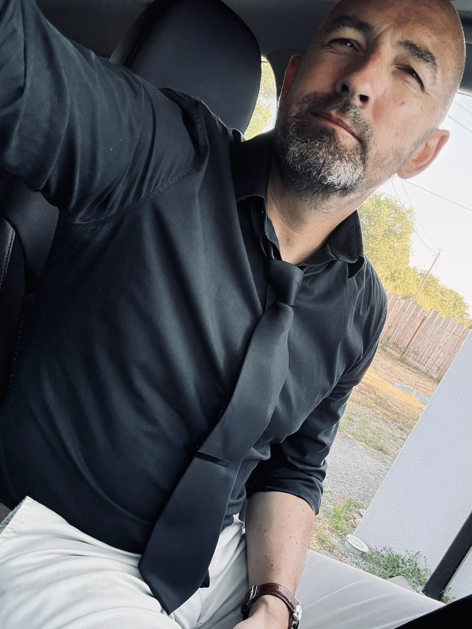 Portrait de François Mougel, photographe de mariage haut de gamme, en chemise et cravate noires