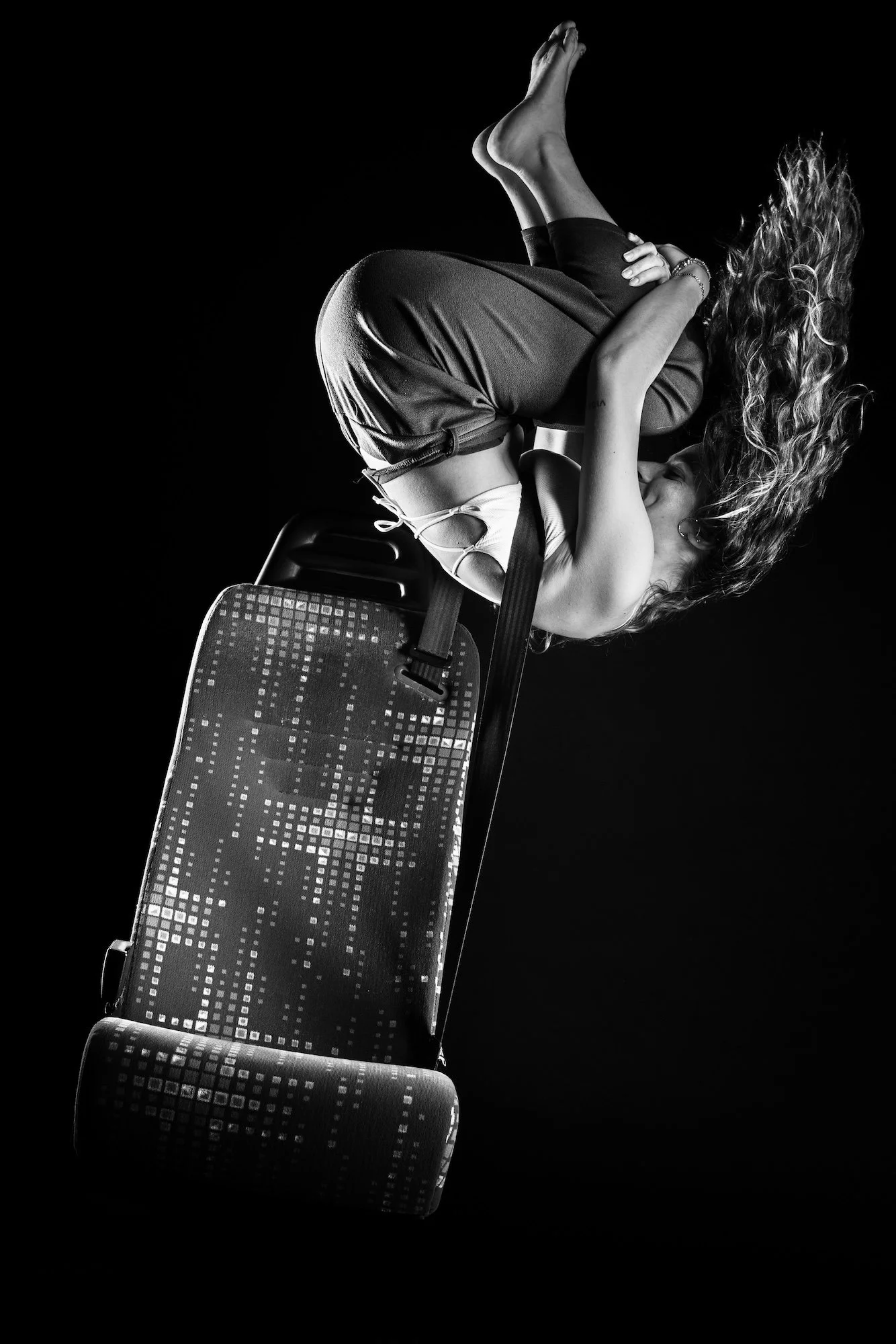 Photographie d’un corps en suspension dans l’eau sur fond sombre, évoquant l’apesanteur et la perte de gravité