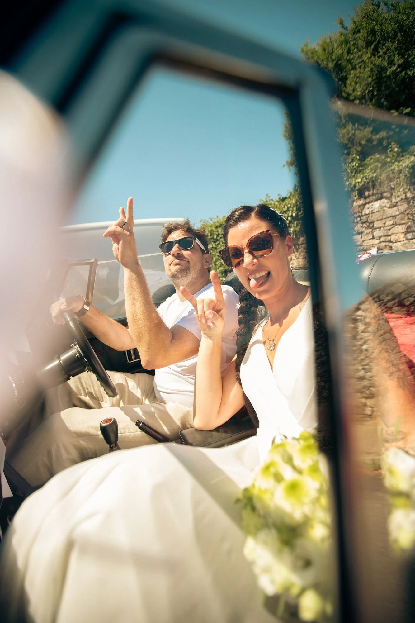 un heureux couple marié au volant d'une voiture de collection