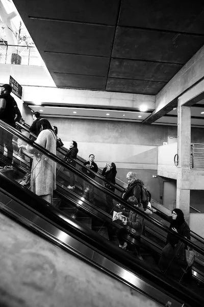 photographie de rue en noir et blanc montrant des silhouettes sur les escalators de le gare de Nantes.