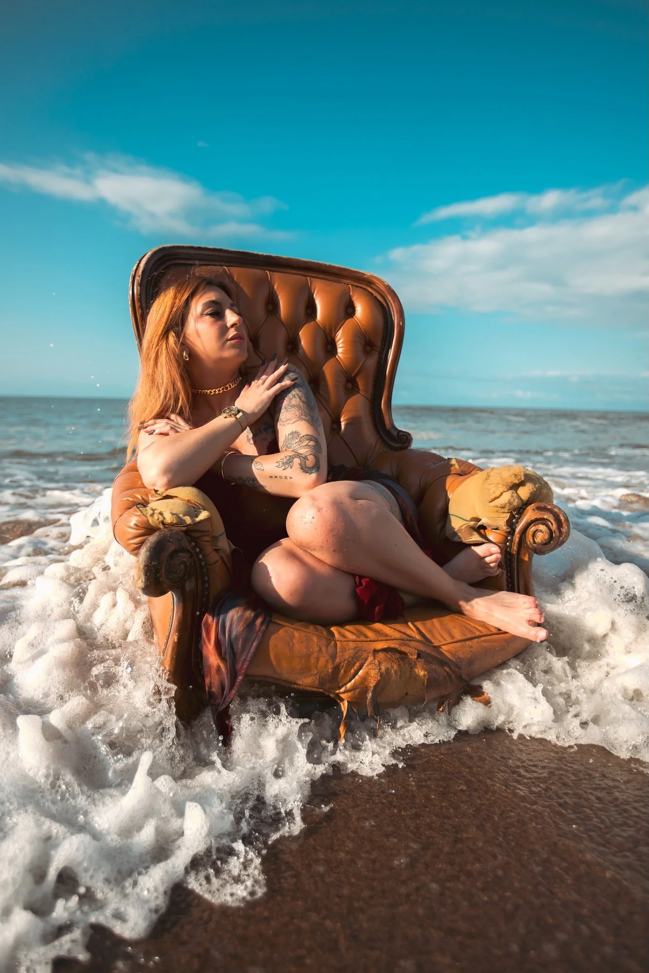 Photographie contemporaine d’un corps installé dans un fauteuil au bord de la mer, confronté aux vagues et à un équilibre instable