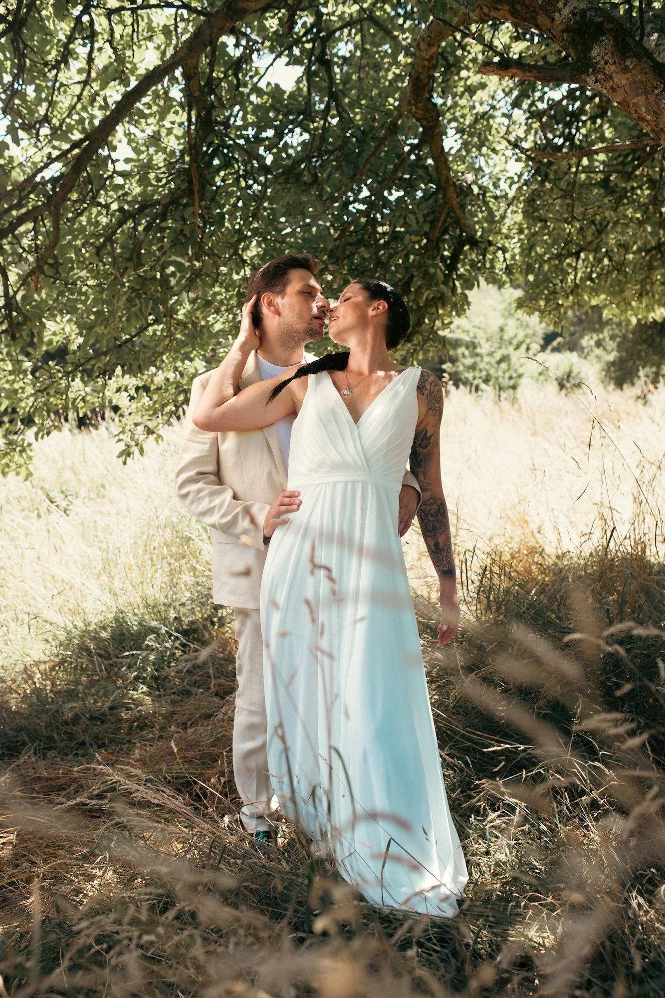 un couple amoureux s'embrasse sous un arbre