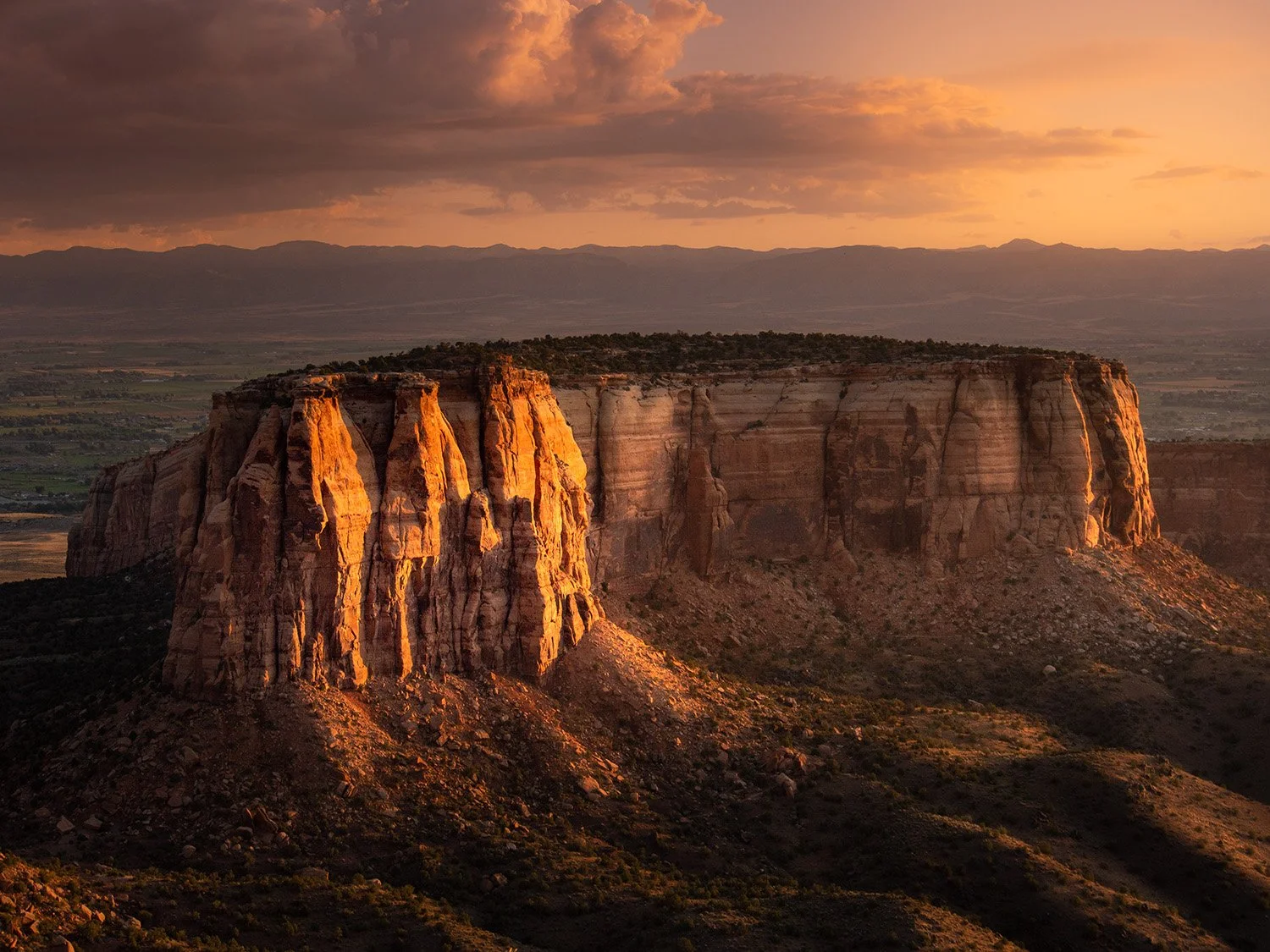 a mesa photographed at sunrise bathed in soft yellow light