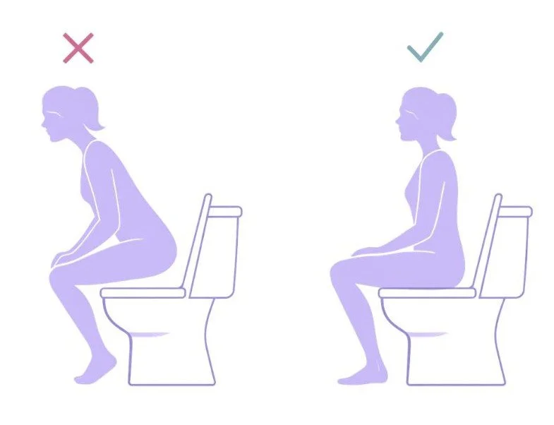 Woman sitting properly on toilet to allow pelvic floor relaxation and complete bladder emptying.