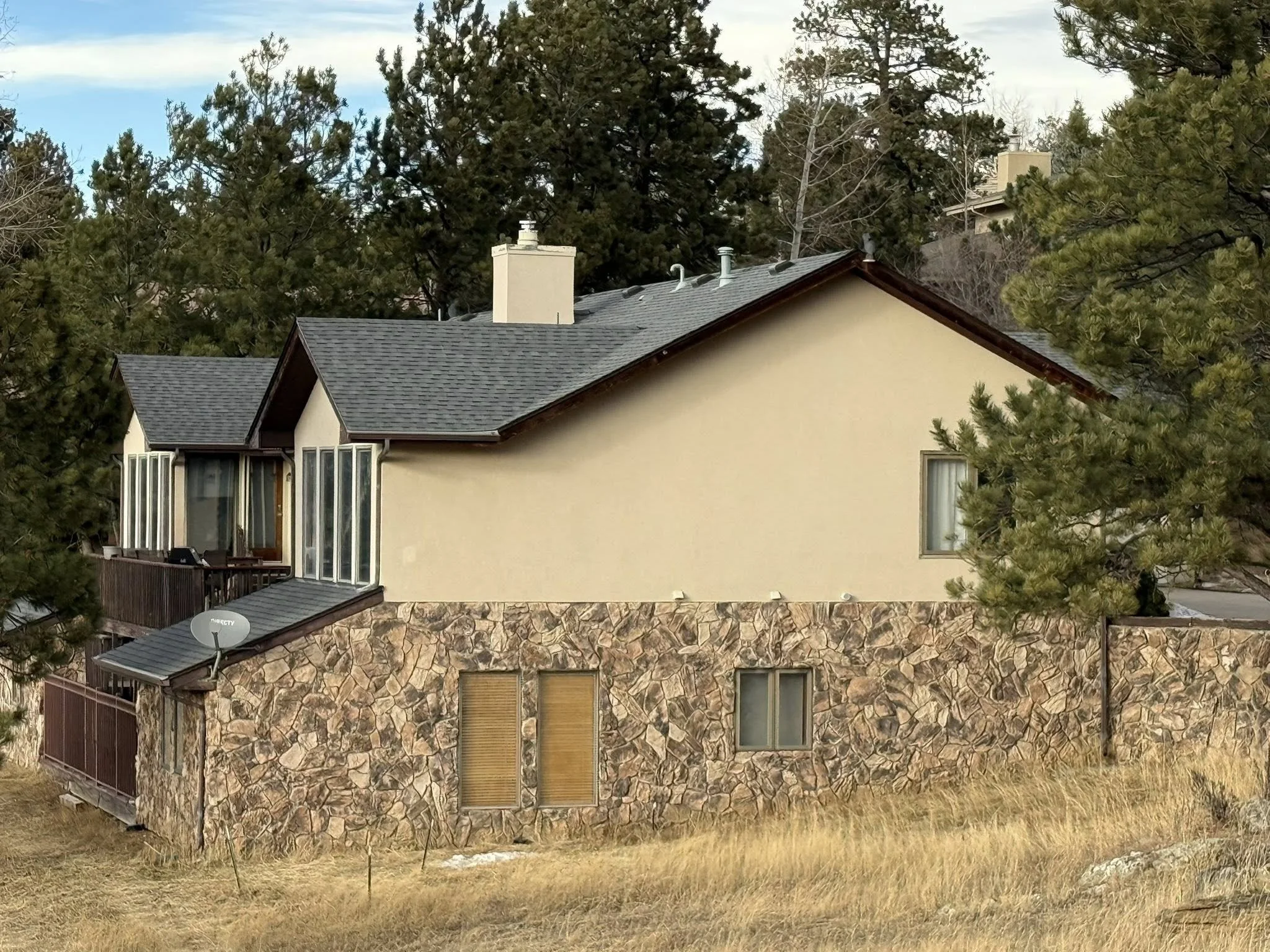Mountain home with a grey roof and stone siding | residential roof replacement in Colorado | Troost Roofing