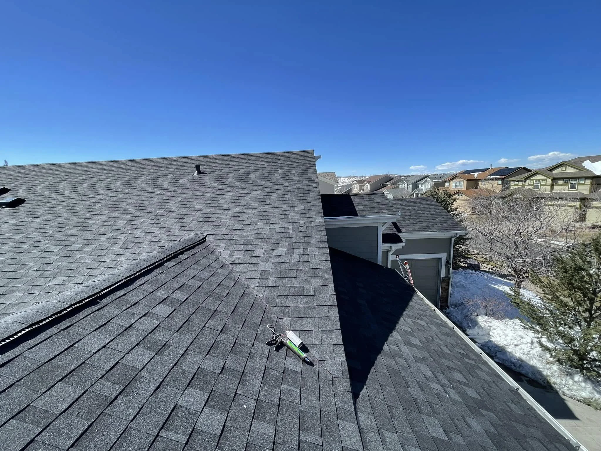 home with a grey roof in a suburban neighborhood | roof replacement for home selling | Troost Roofing
