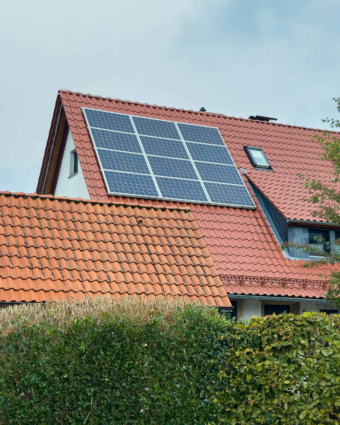 solar panels on a maroon roof | roof replacement with solar panels | Troost Roofing