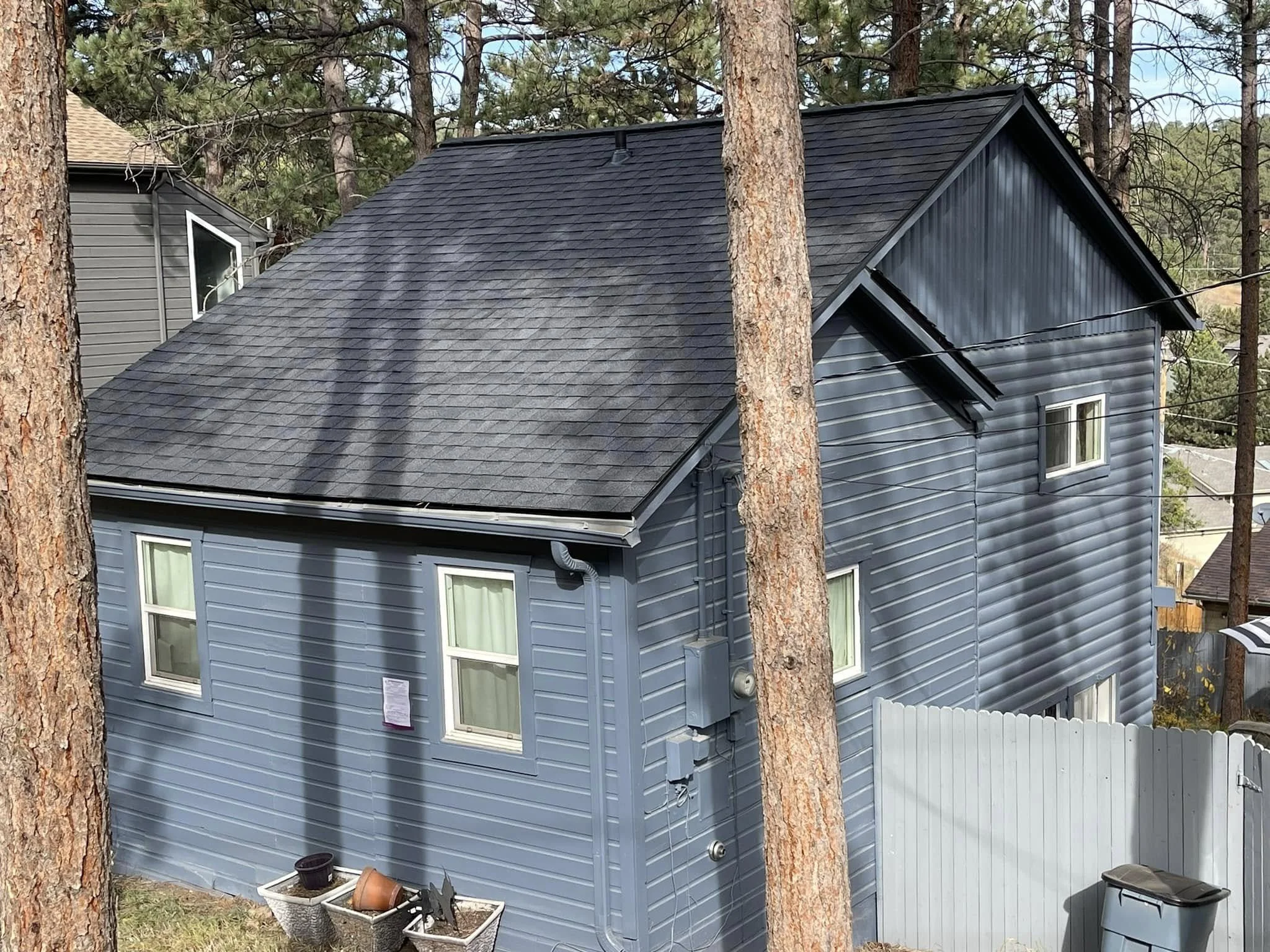 example of roofing in Idledale, CO: gray asphalt shingles on a deep green home.