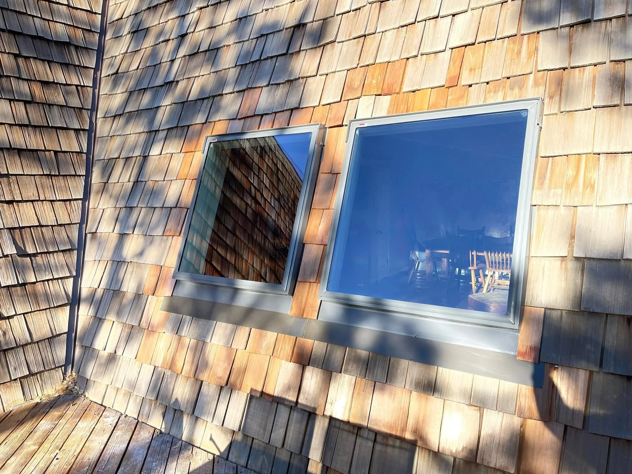 an example of denver roofing: light brown composite roof with two windows set into the roof.