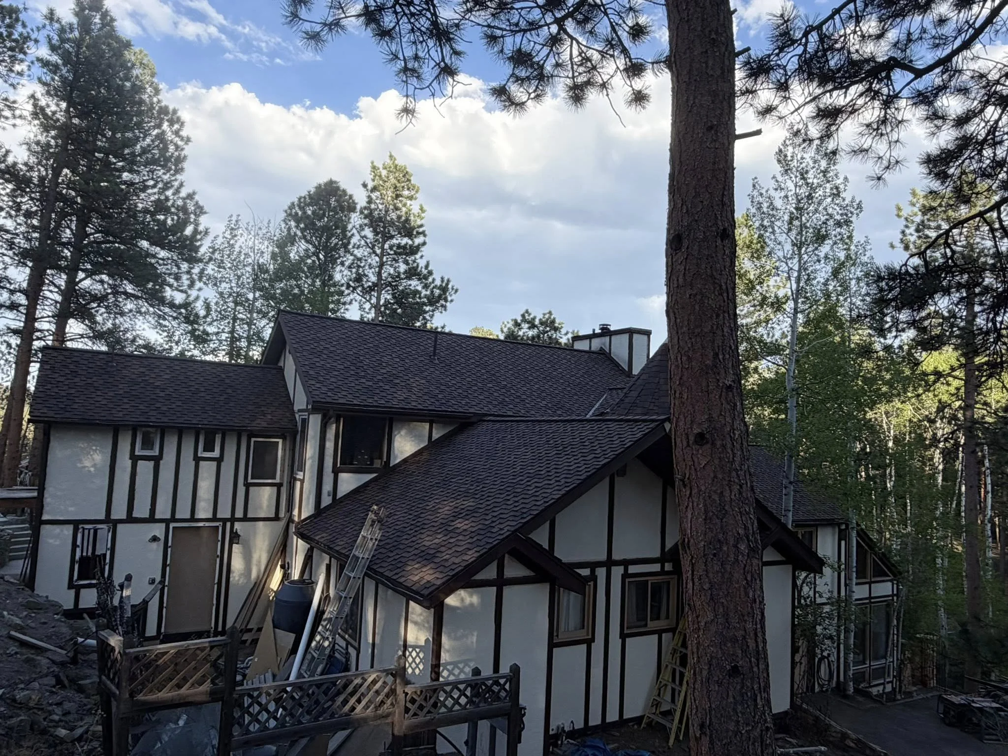image of a beautiful white home with a black roof | shingle roof lifespan | Troost Roofing