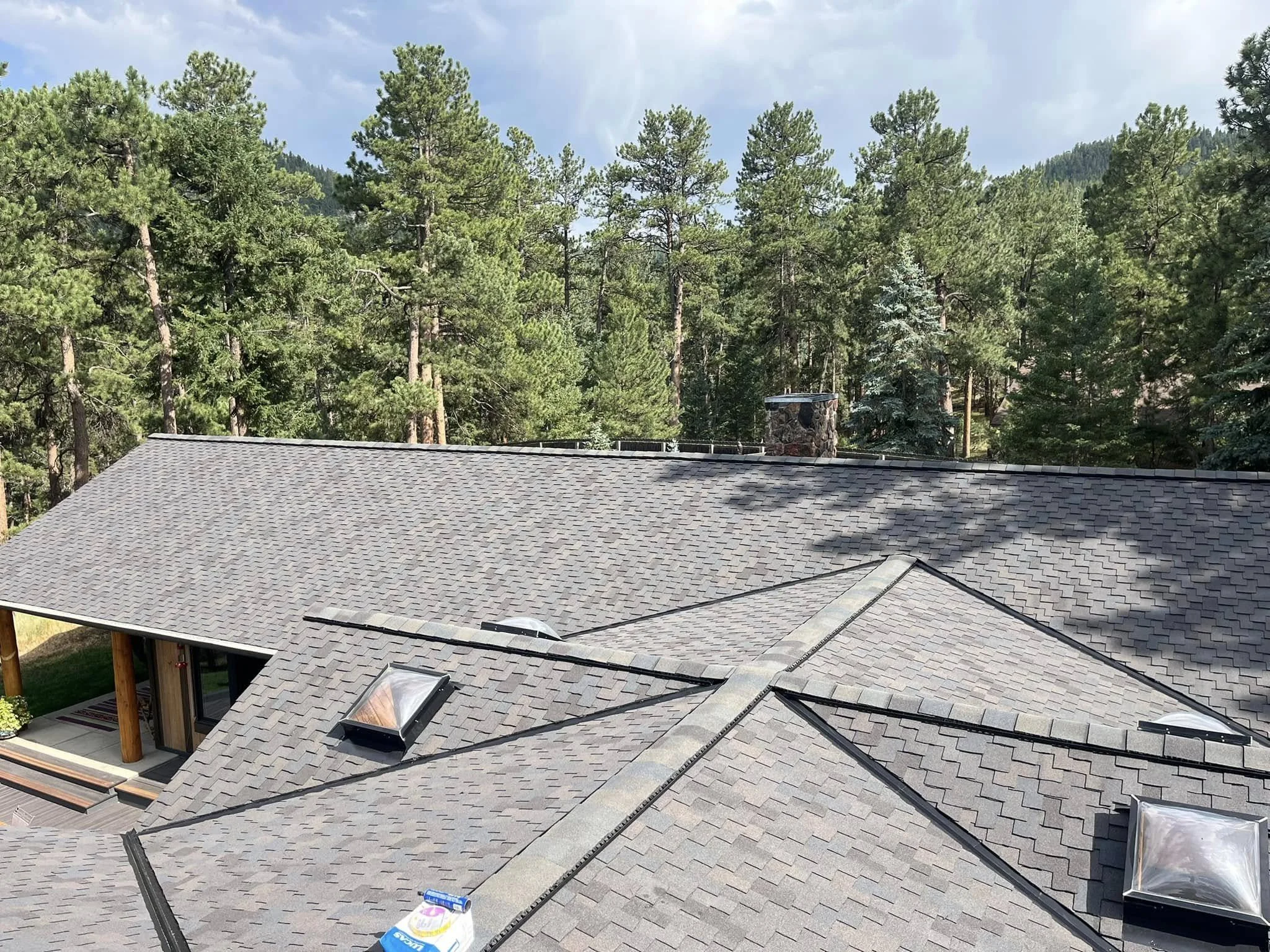 grey geometric roof surrounded by trees | Impact-Resistant Shingles | Troost Roofing