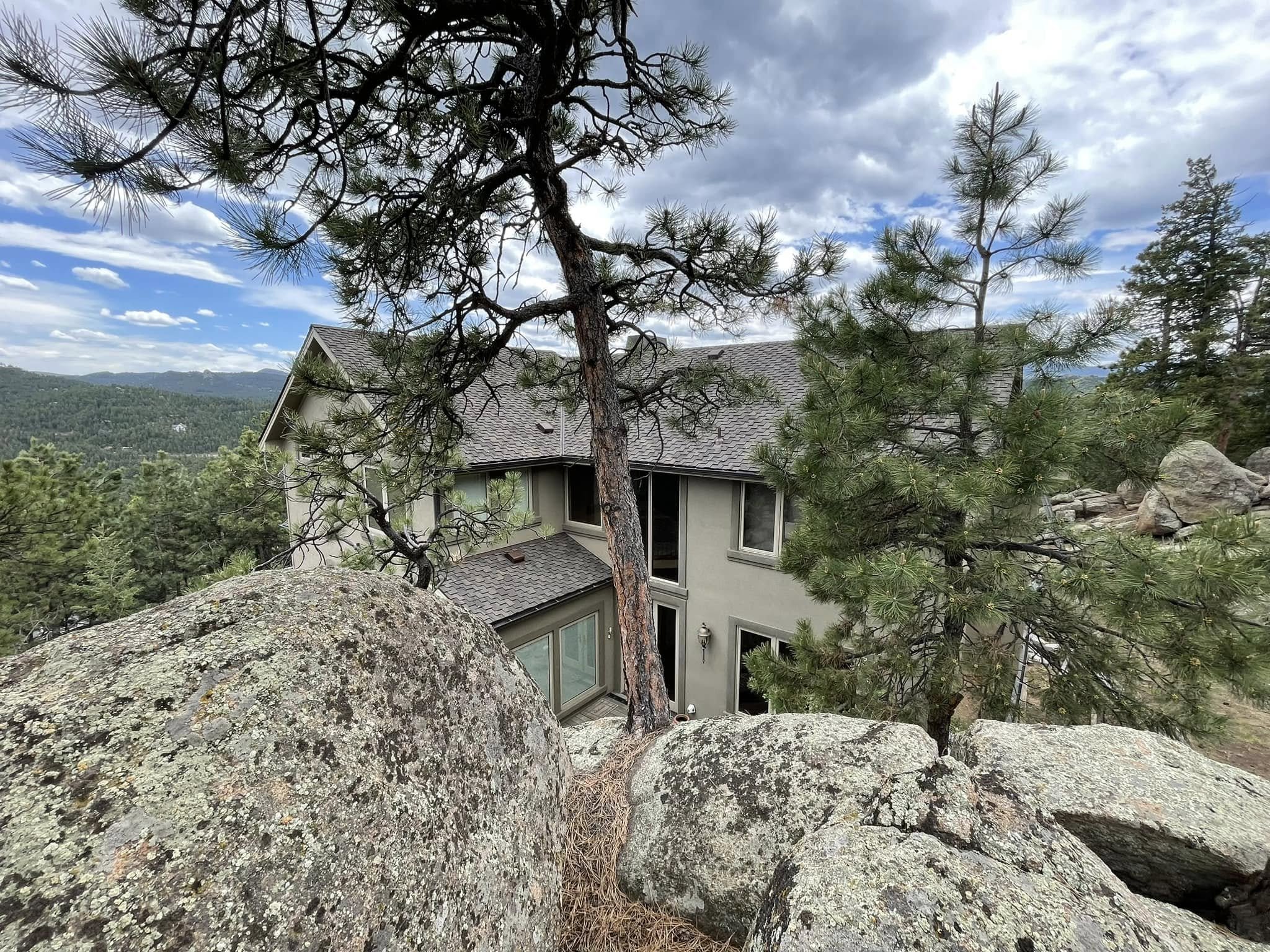An example of Evergreen, CO roofing with a grey roof being photographed over a rock foreground