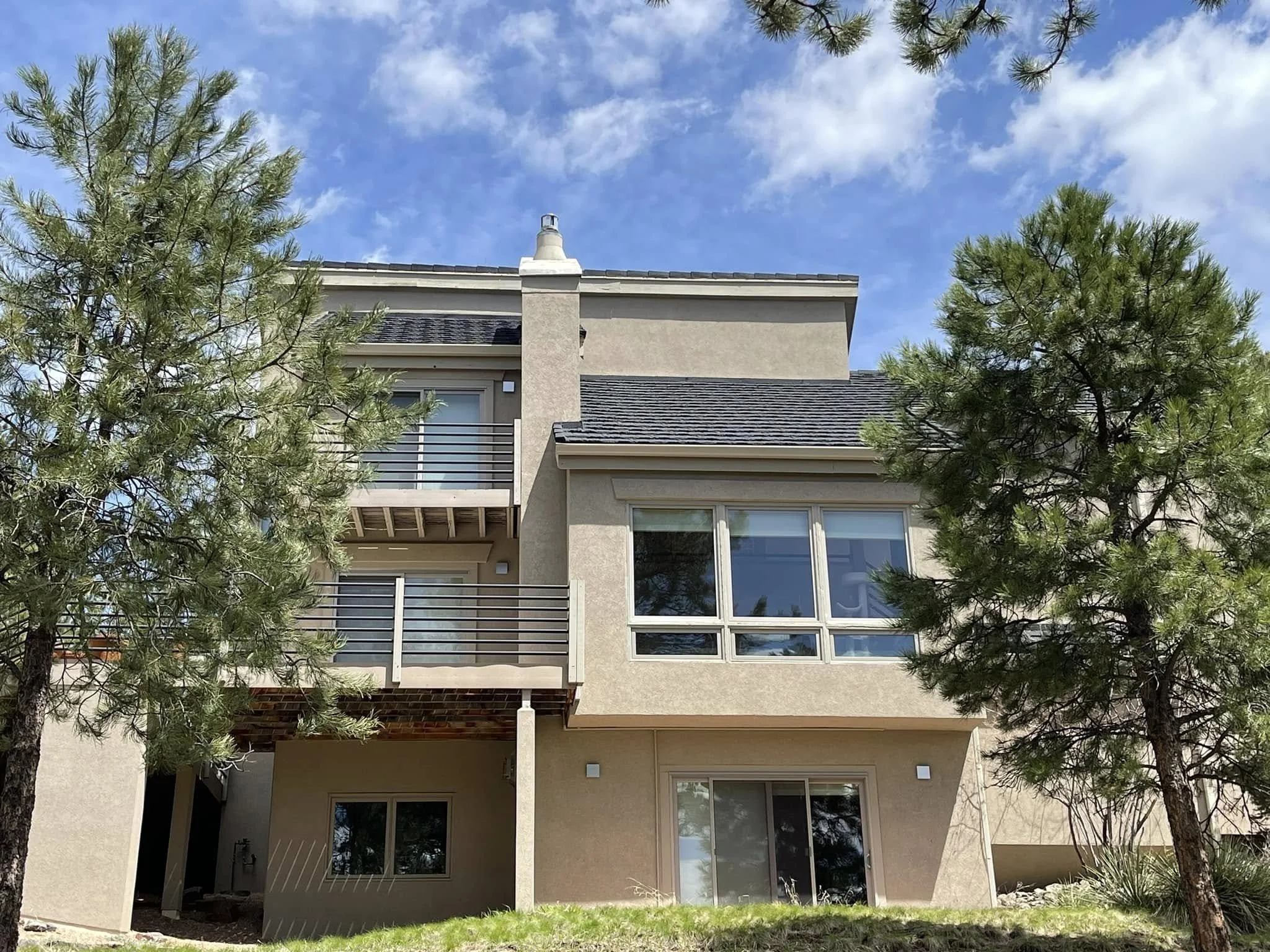 a condo with denver roofing' light grey shingles on a beige property.