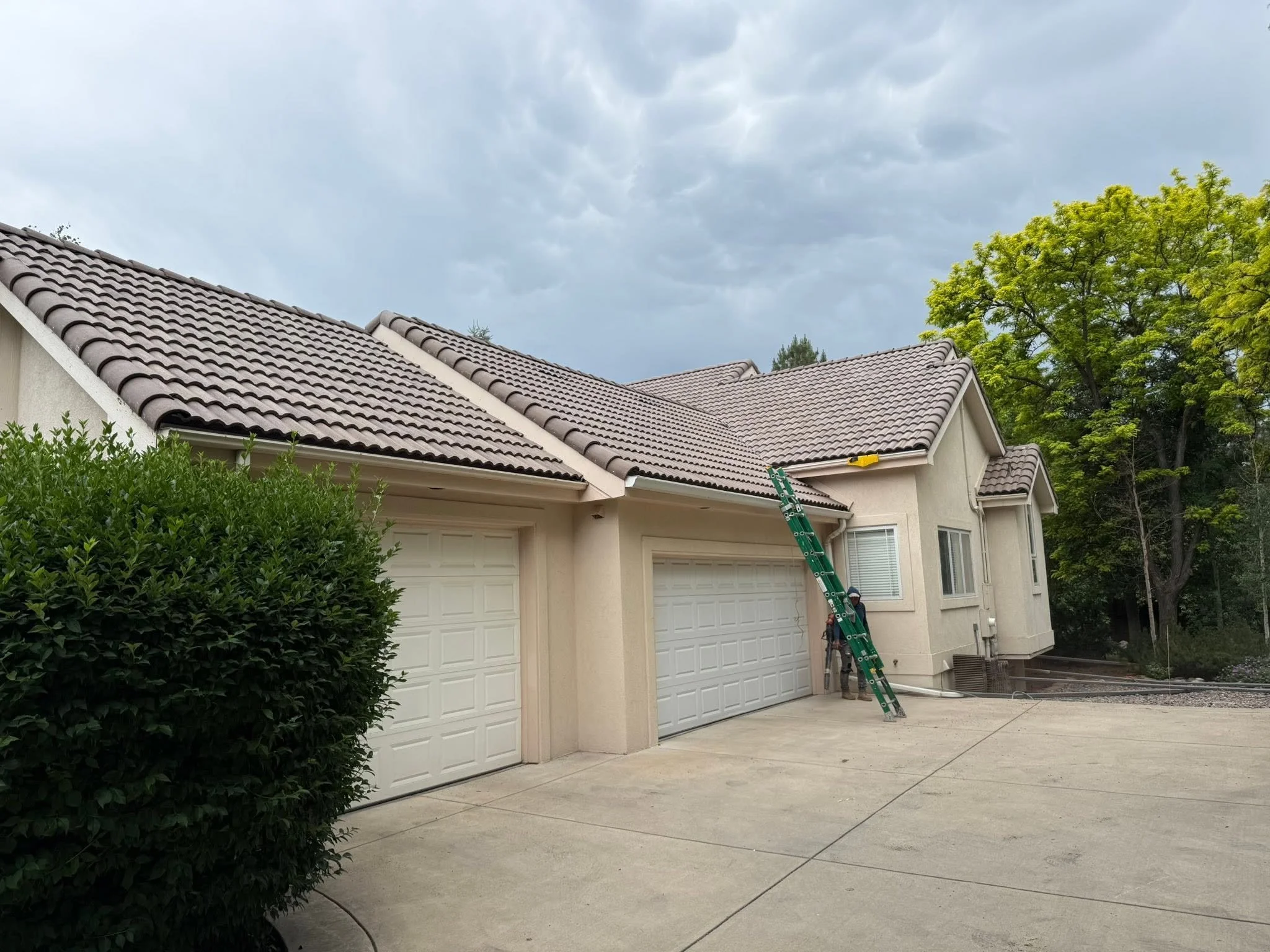 Evergreen, CO gutters freshly installed on a beige home with tan clay roof tiles