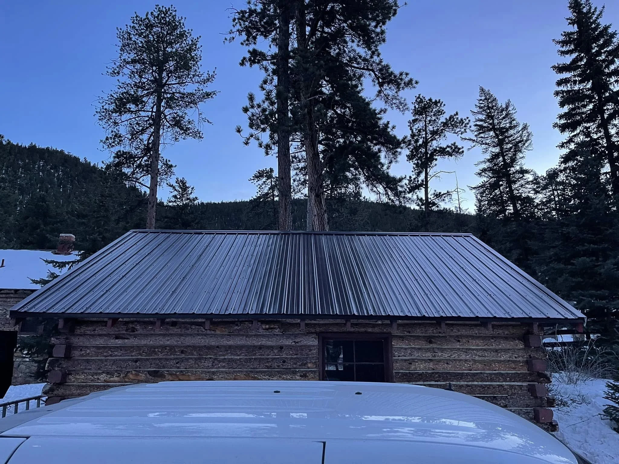 an example of Evergreen, CO roofing: a metal roof installed on a mountain cabin-style home