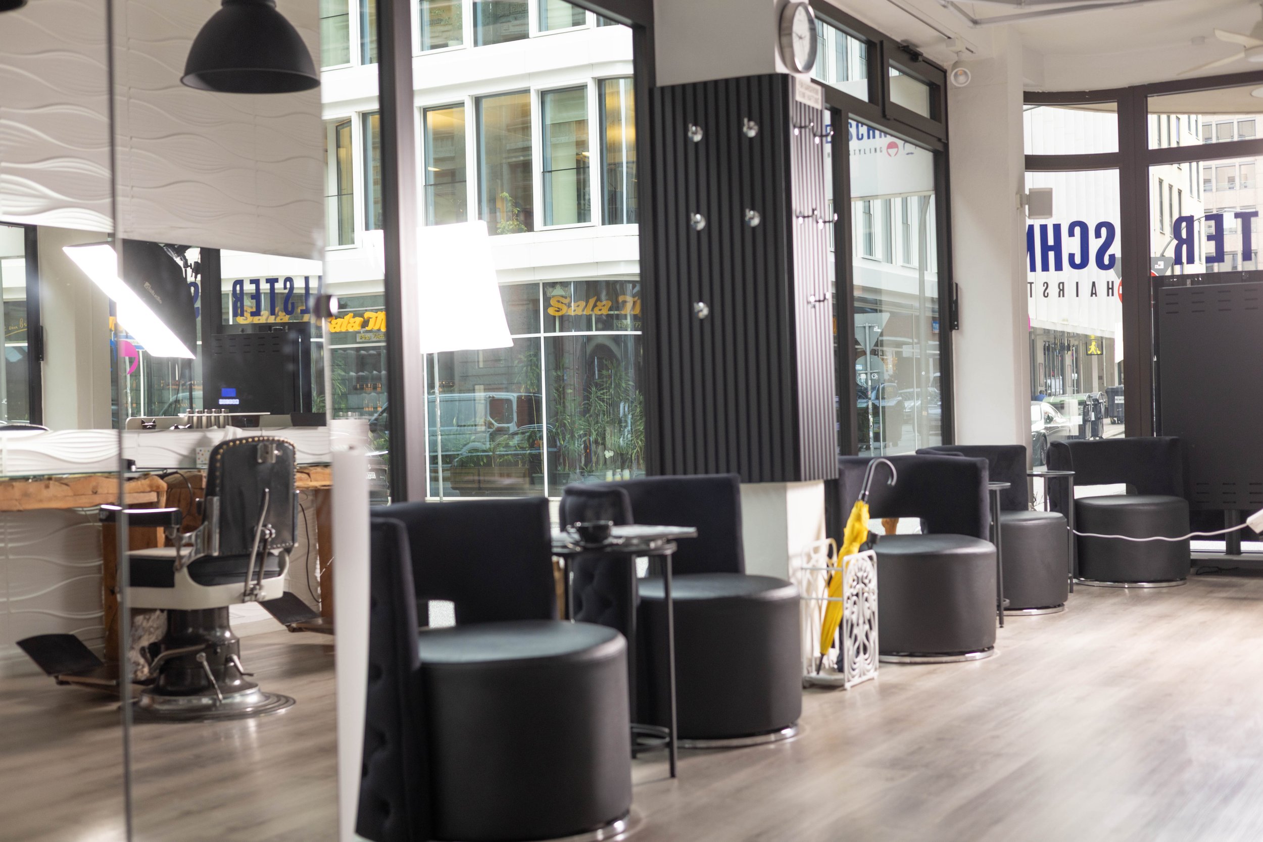 Wartebereich mit Sesseln am Schaufenster des Friseursalons Alsterschnitt in der Hamburger Innenstadt