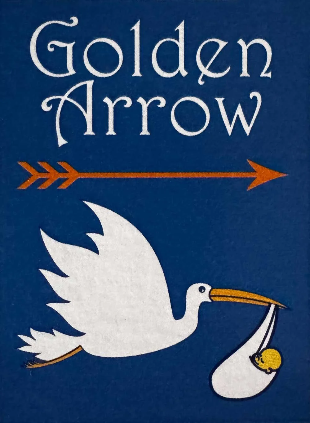 A blue background with the text 'Golden Arrow' and an orange arrow pointing right. Below, a white stork with an orange beak is holding a yellow chick with a white blanket in its beak.