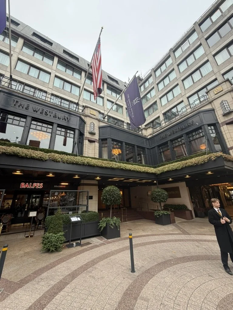 Exterior of The Westbury Hotel Dublin with dark grey facade, purple flags, and Balfes Brasserie entrance.