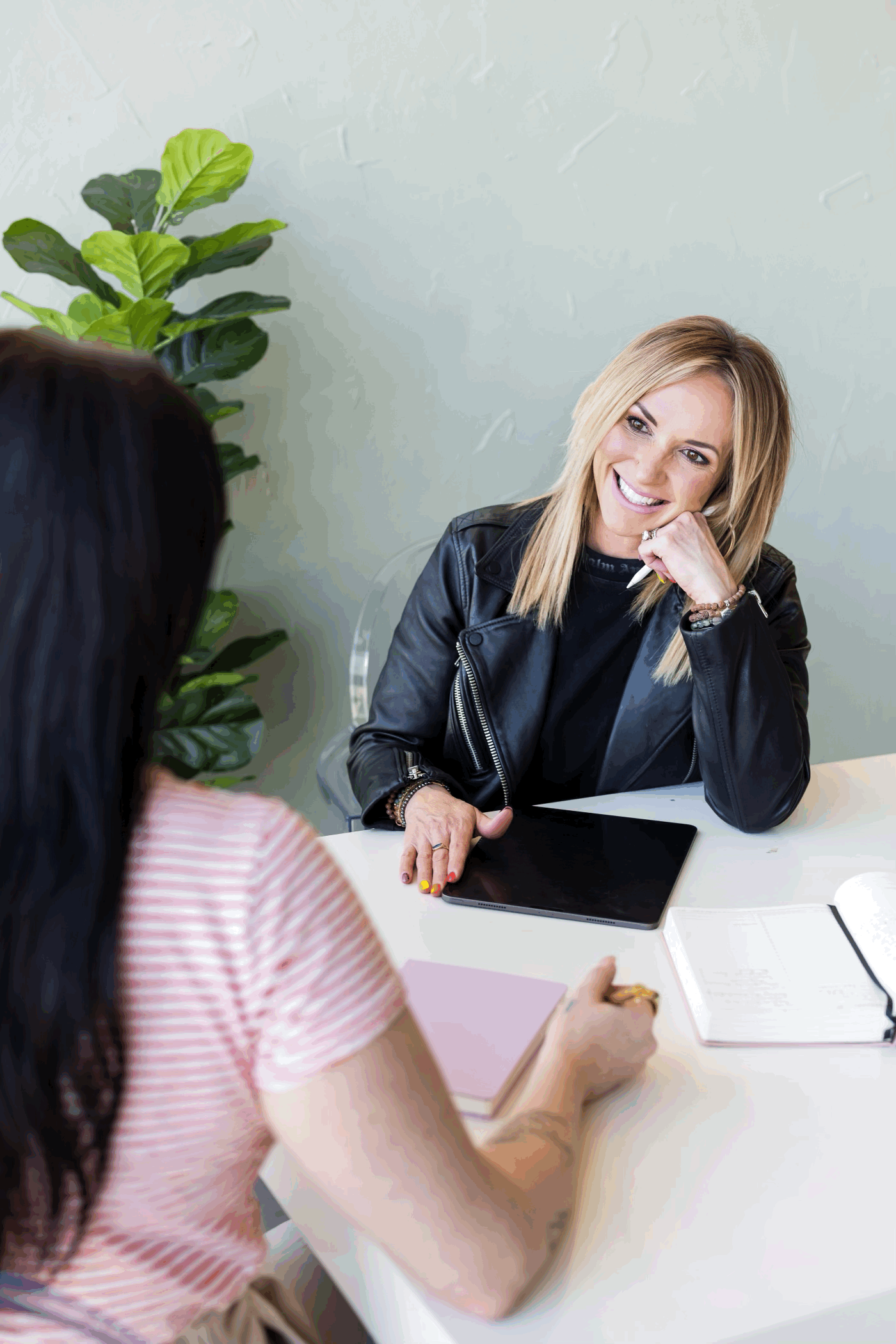 Drea Hemmer smiles at a woman across the table from her, engaging in conversation.