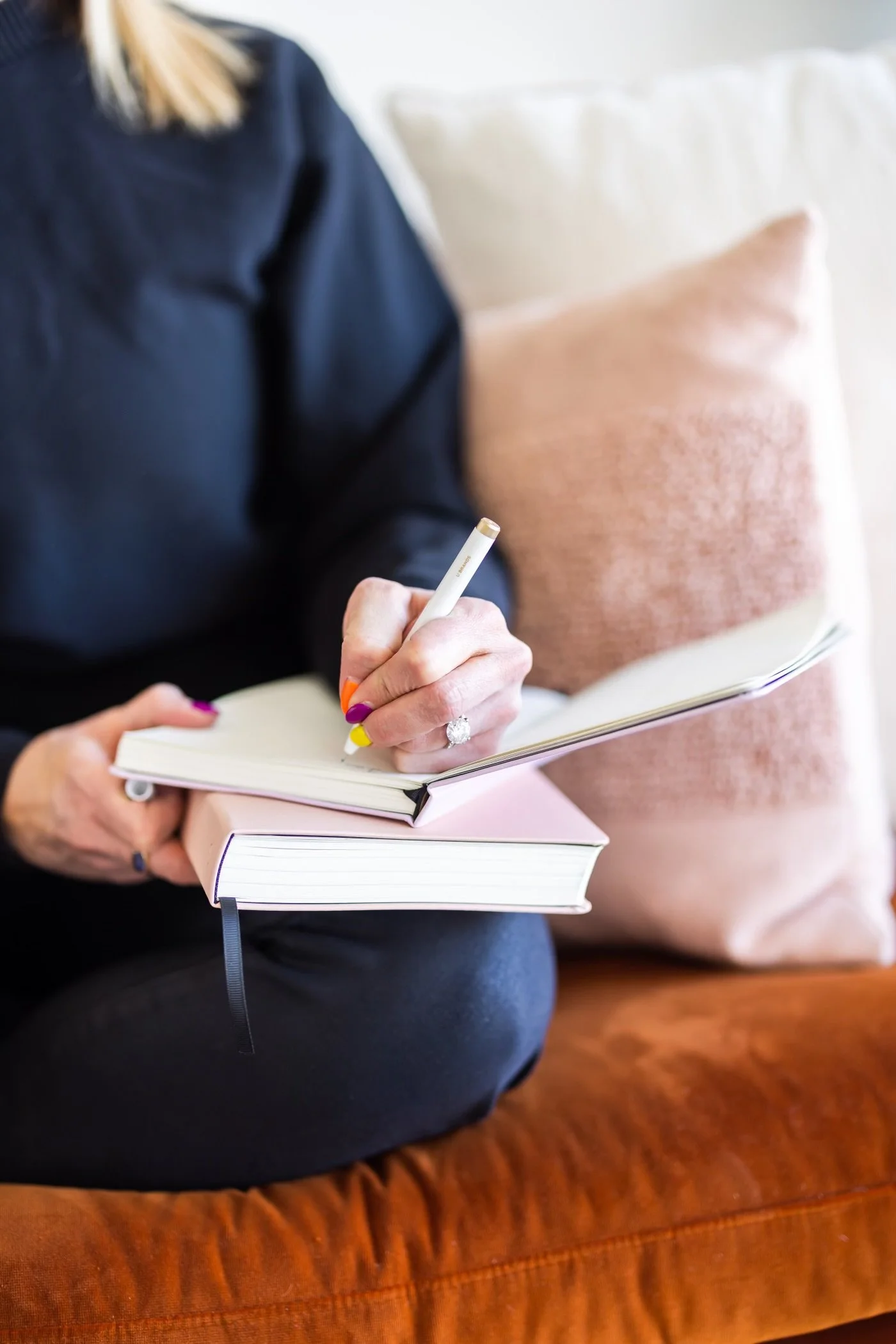 A woman sits, planning out a meeting agenda in her journal.