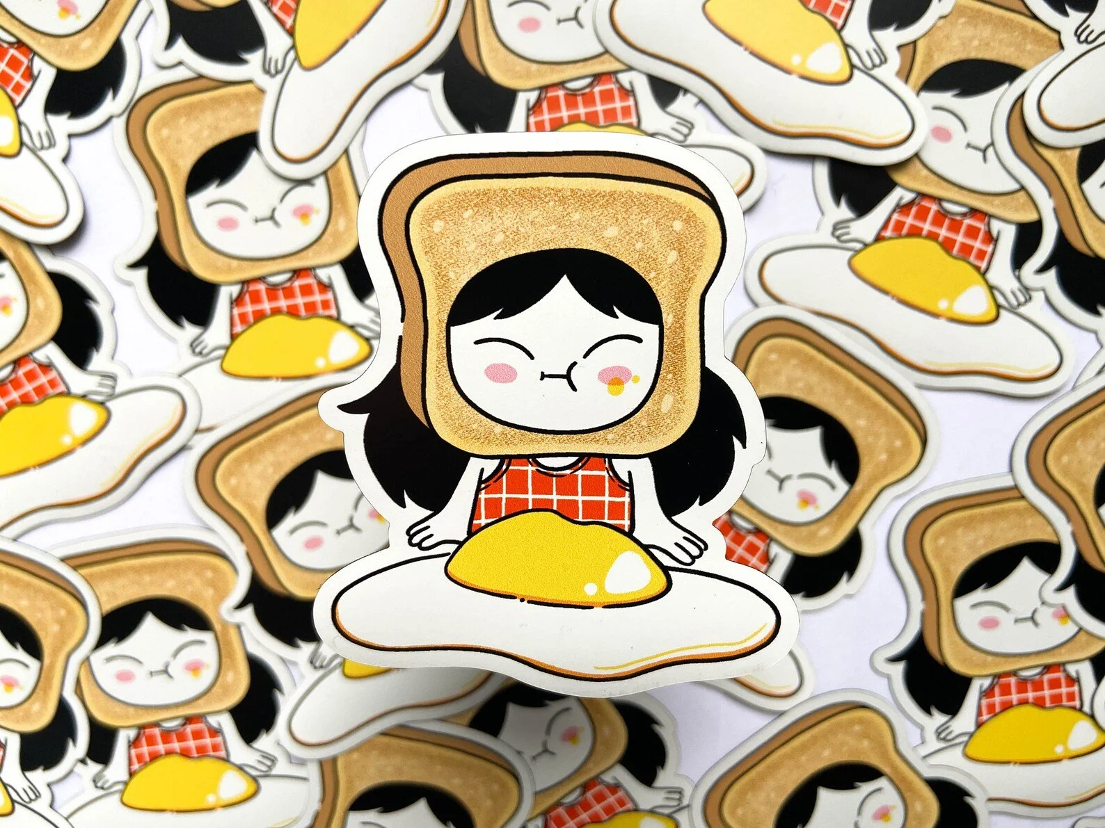 magnets of a smiling girl with toast around her head and a sunny side up egg in front of her