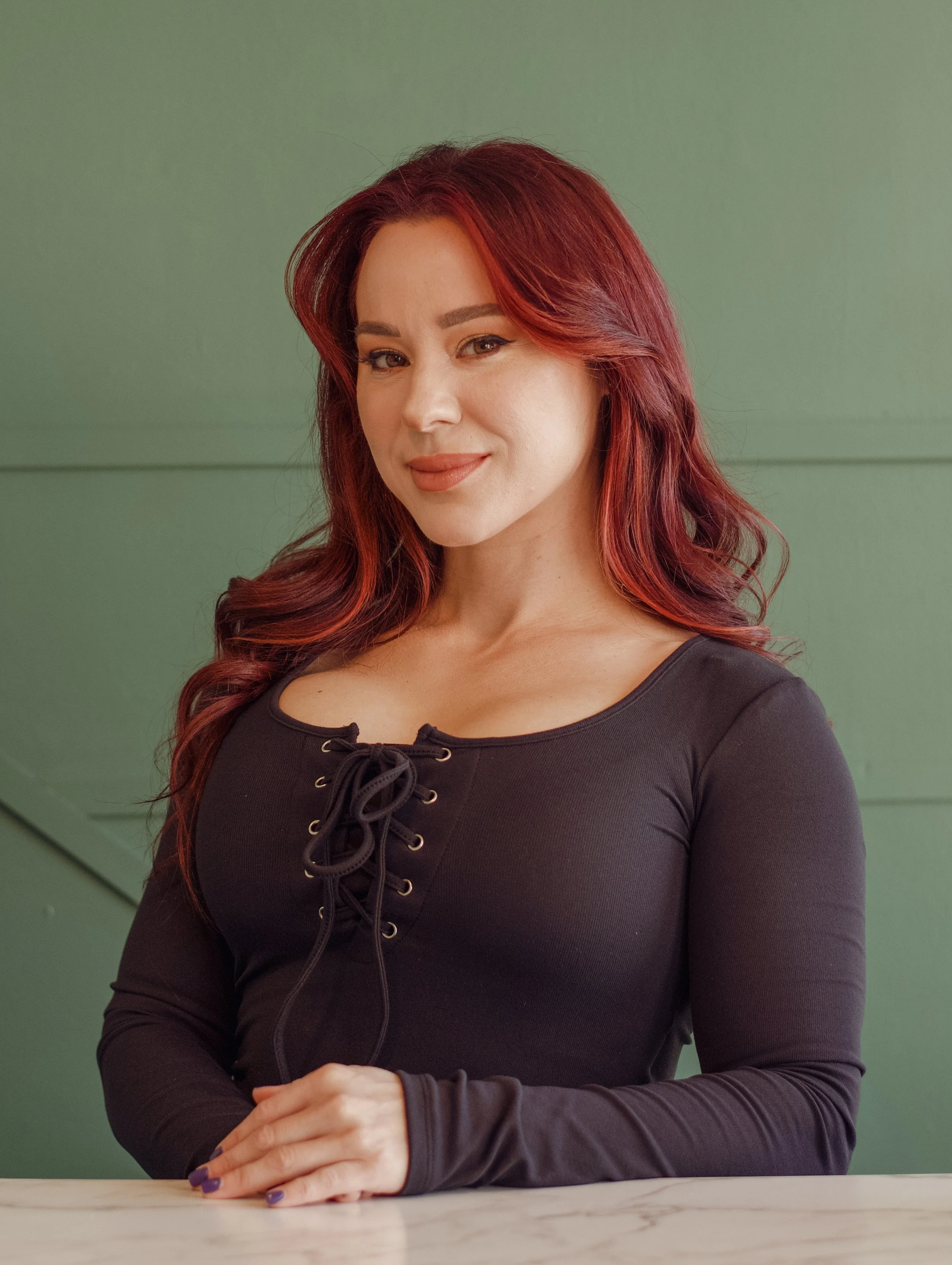 Beauty tools including a jade roller, a facial massage roller, and a facial cleansing brush on a white surface.