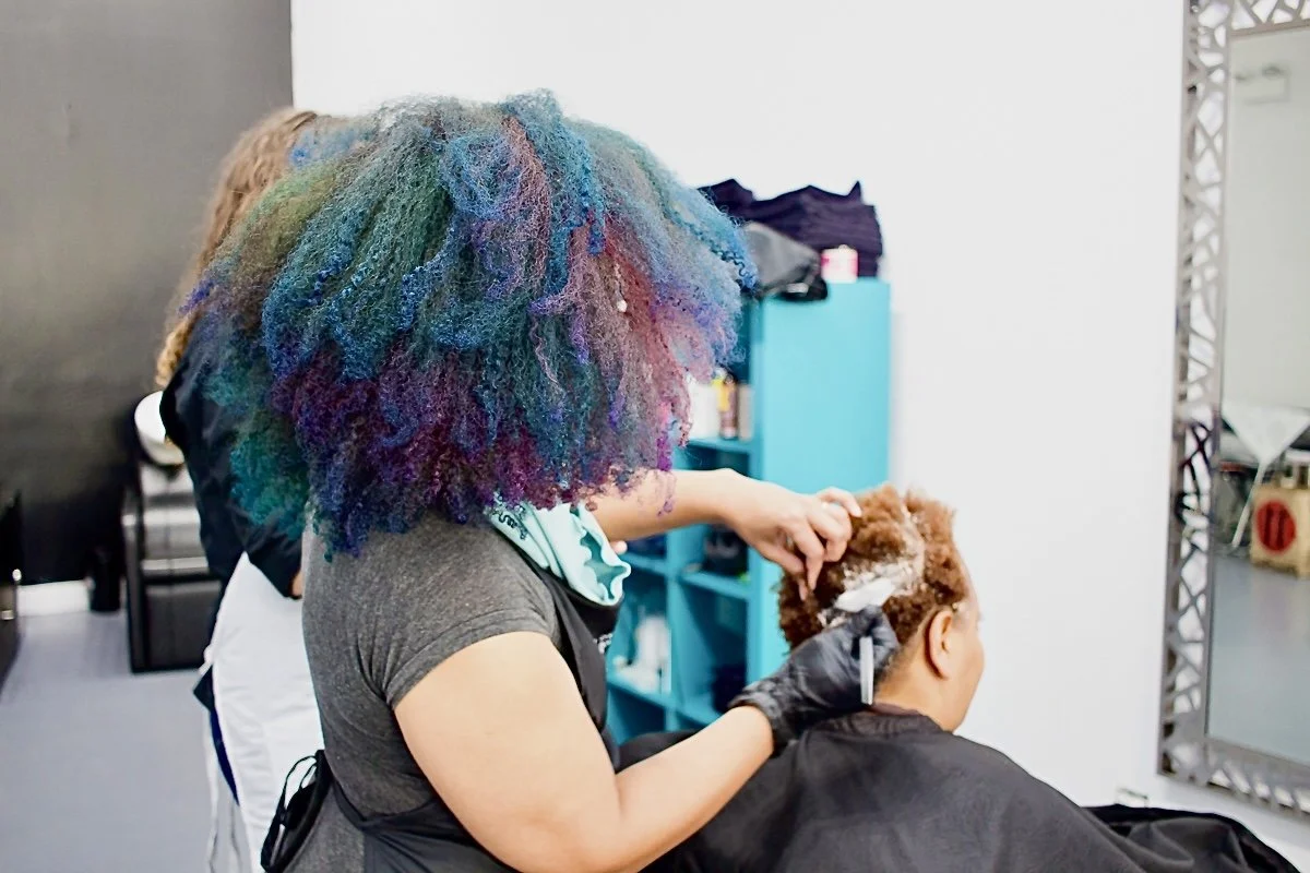Atlanta curl artist Aeleise Jana A hairstylist with colorful, rainbow afro hair crafting a custom hair color in neutral  tones and grey coverage in her Neon & Neutral Curl Color Studio in Fayetteville, GA