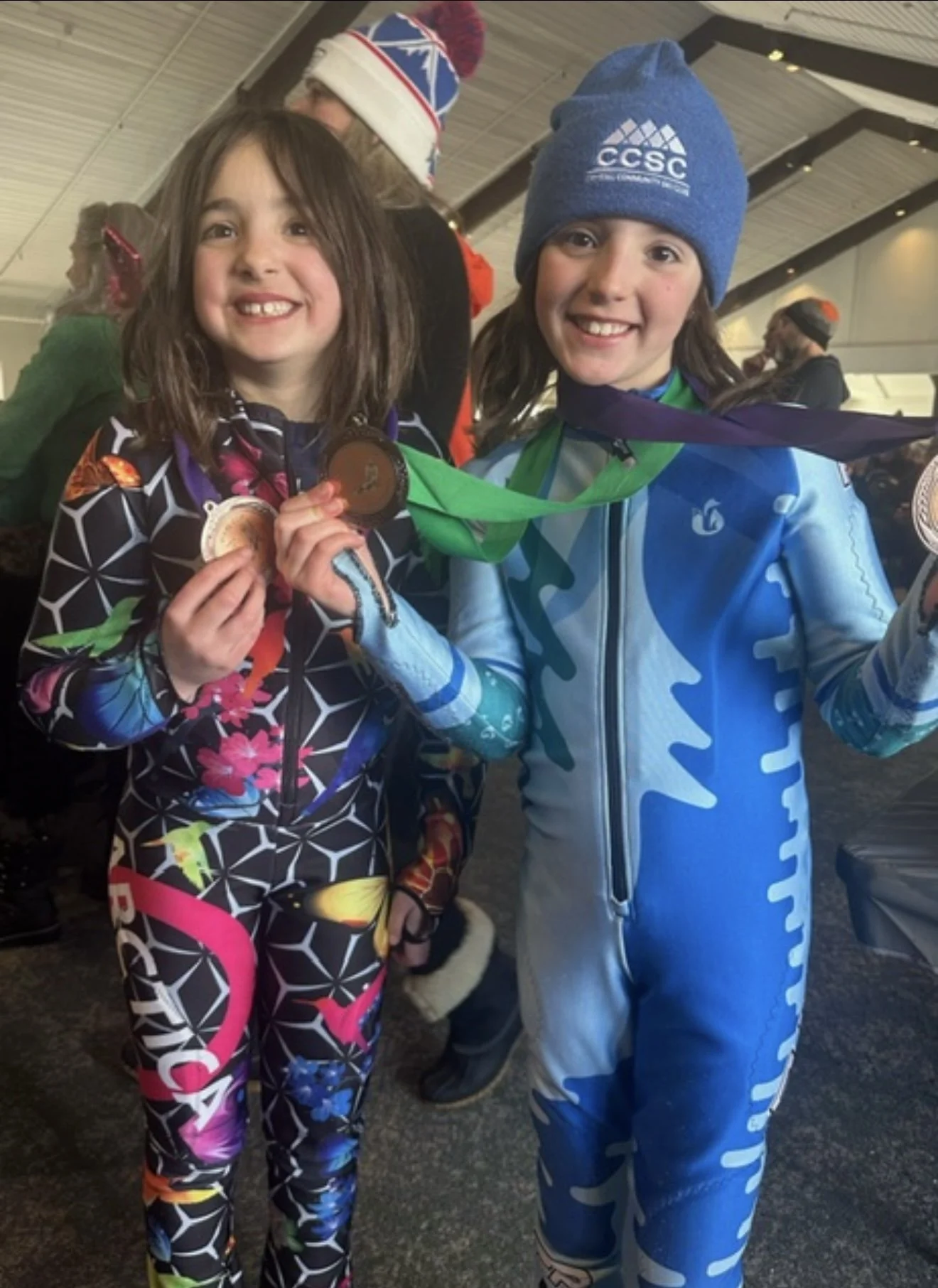 Two girls showing medals from a club race