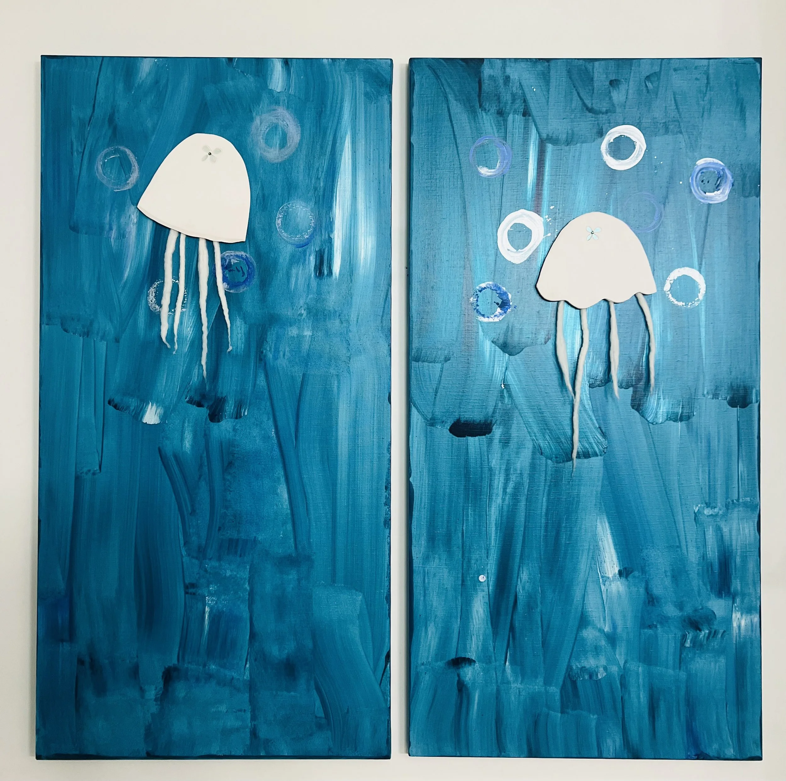 two white jellyfish in a blue ocean