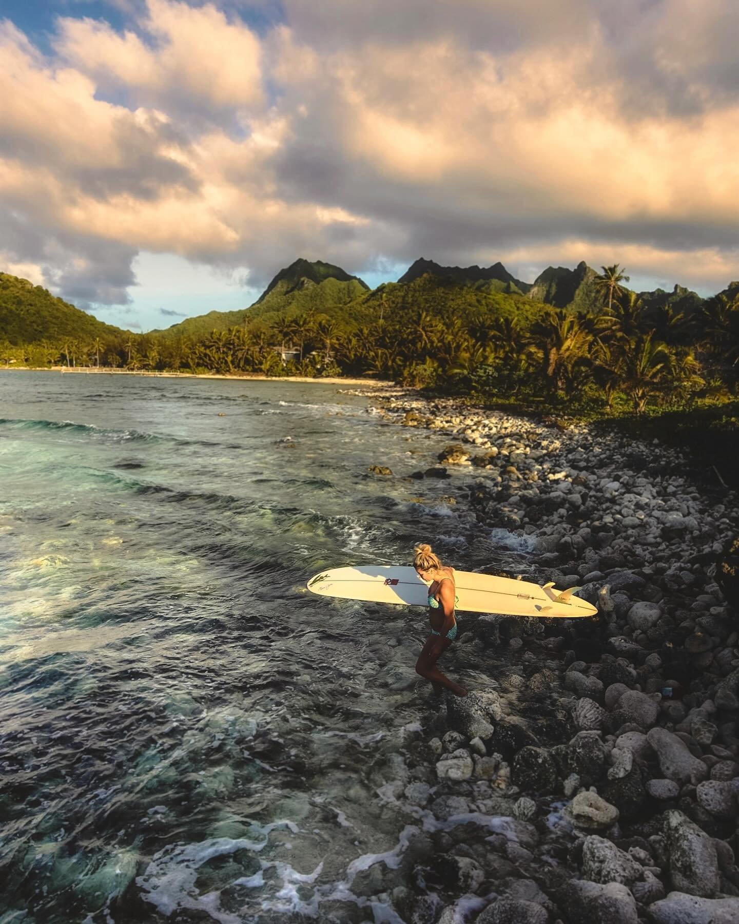 Mary Osborne heads out for an evening surf session on the island of Rarotonga in the Cook Islands. We arrived in the Cook Islands after a 7-day sail from Tahiti and couldn&rsquo;t wait to get in the water for a much-needed surf. Our seven-day journey