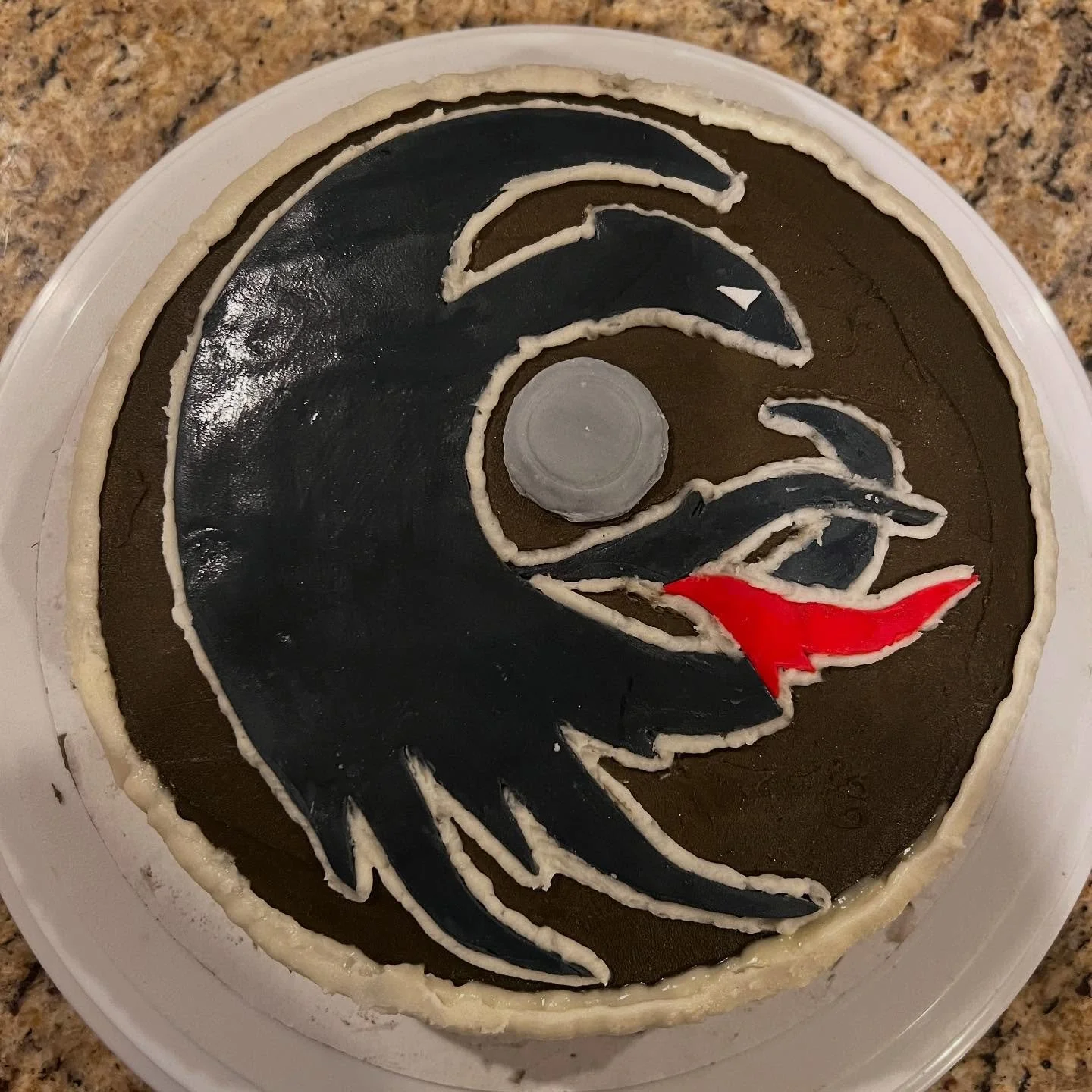 My oldest turns 12 this week and wanted the Toothless Nightfury dragon design on Hiccup&rsquo;s shield from How to Train Your Dragon for his birthday cake. The design is fine but I need lots of straight line\ribbon piping work. If I did this again, i