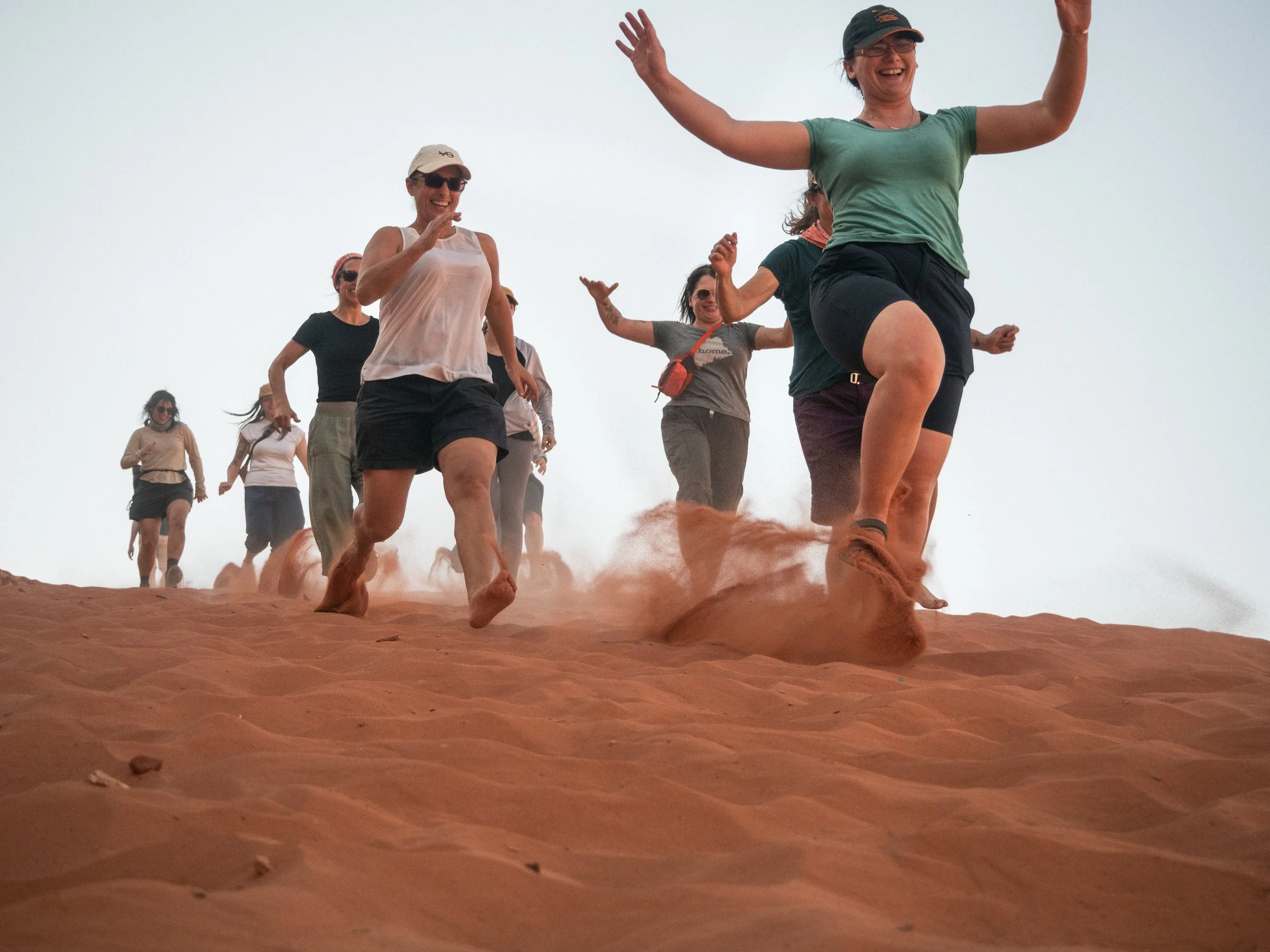 women running down sand dune