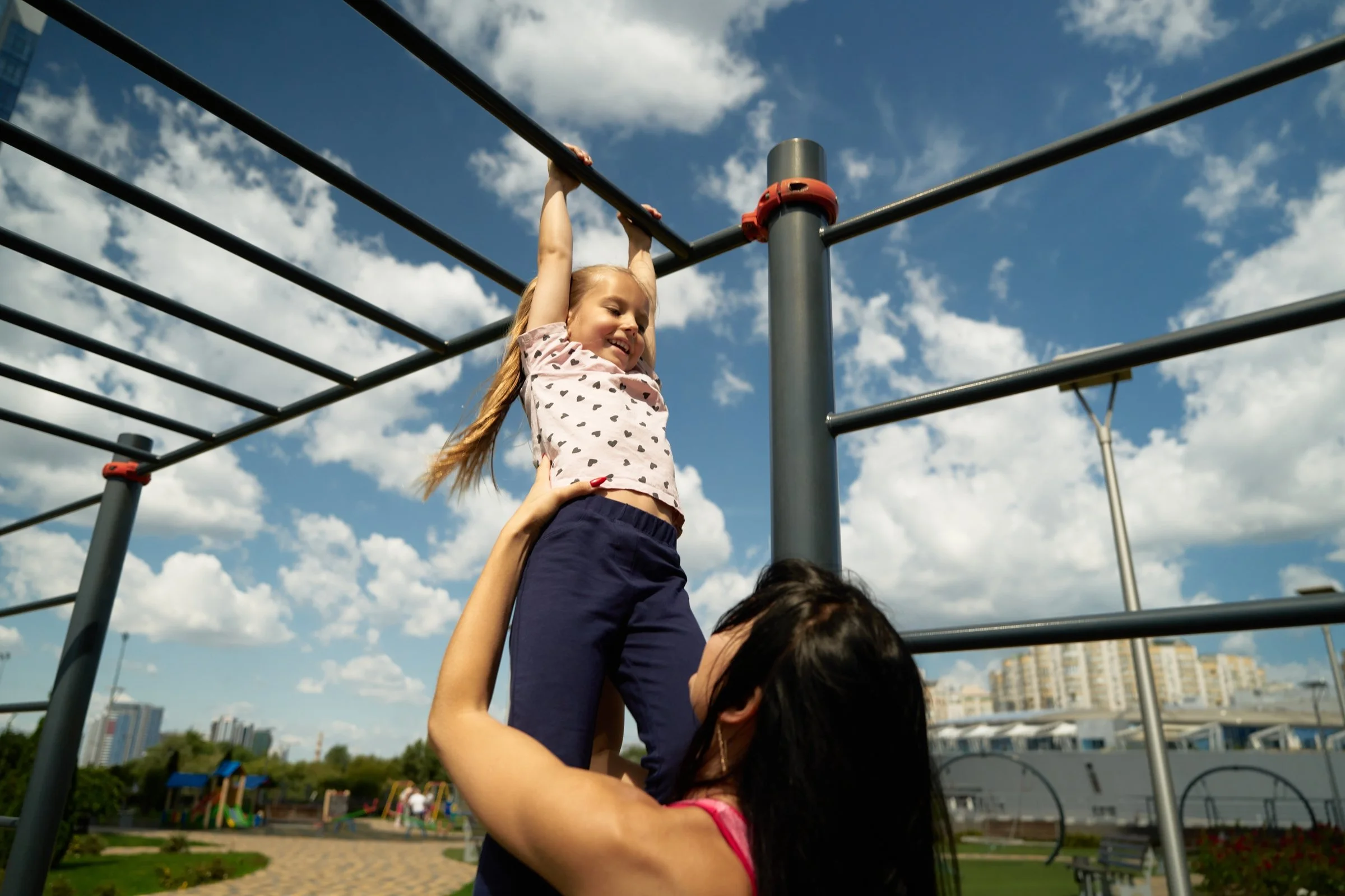 Nanny engaging child in outdoor play during Boston summer