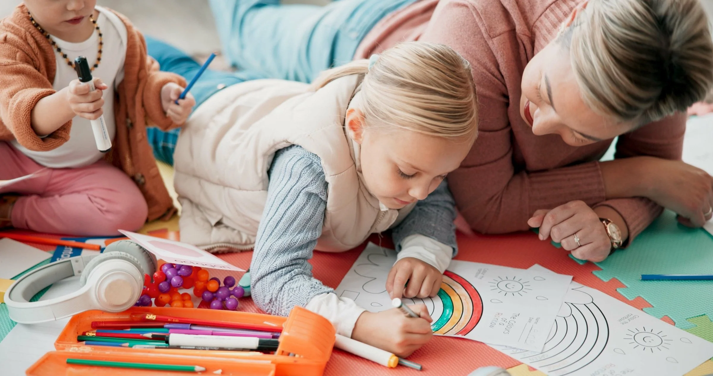Professional nanny engaging children in structured indoor summer activity at home