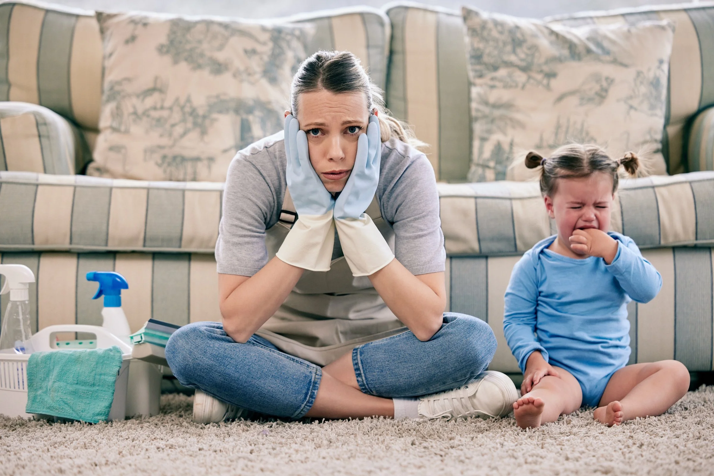 Overwhelmed mother managing household tasks with a child in a busy home