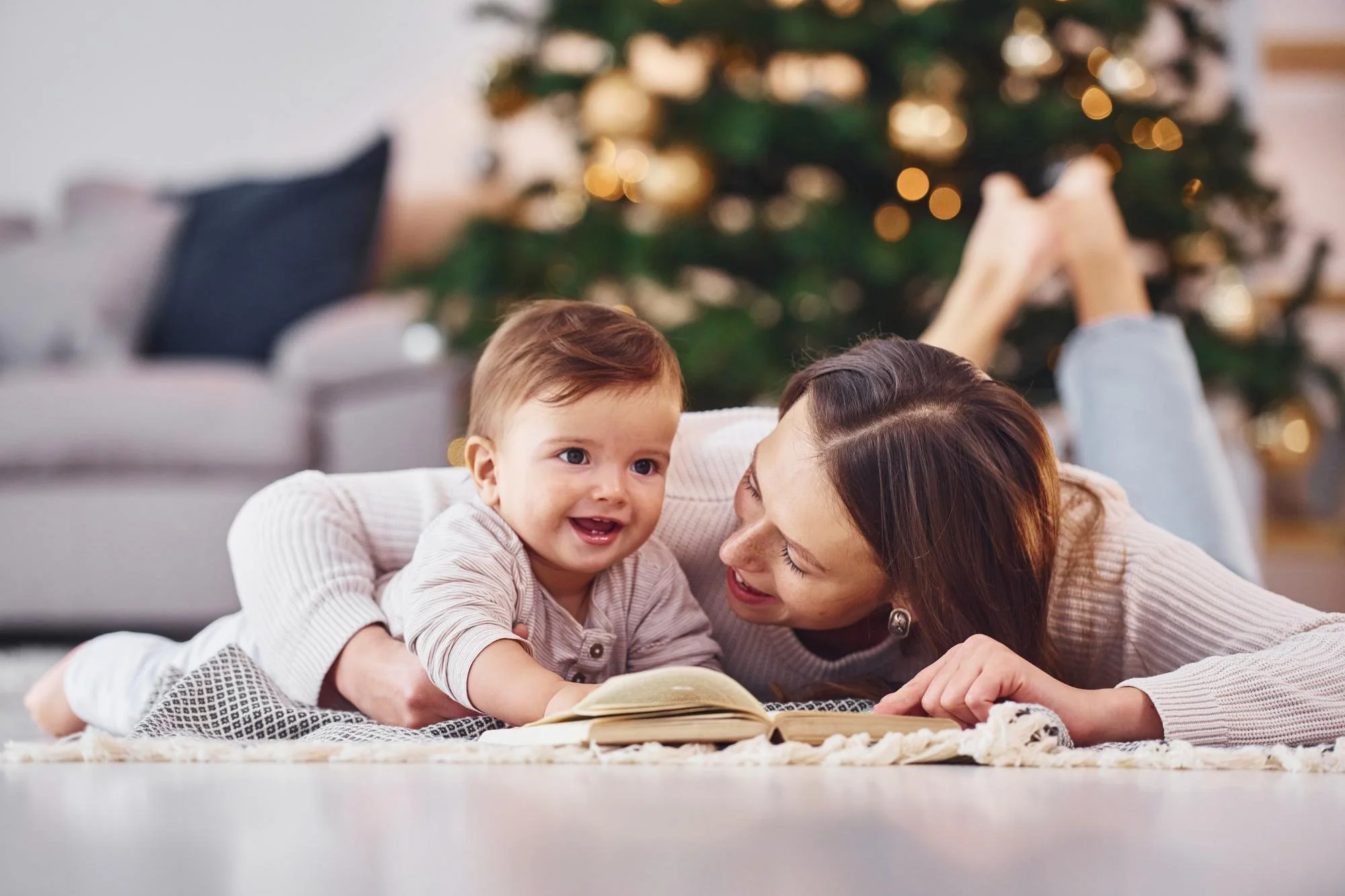Nanny reading to baby during cold weather indoors in Cleveland.