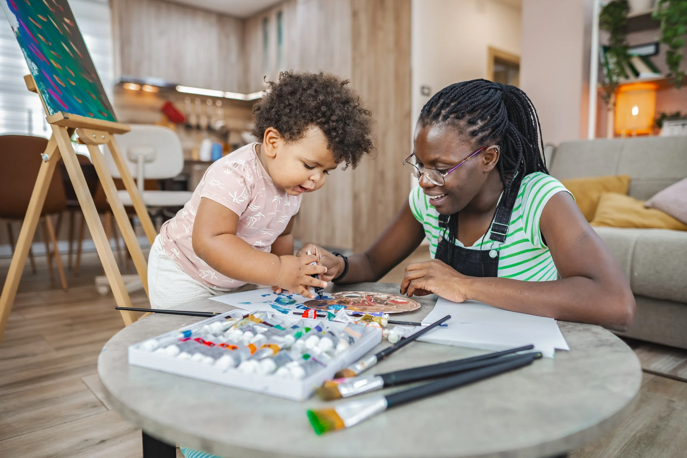 Nanny helping child create handmade holiday cards