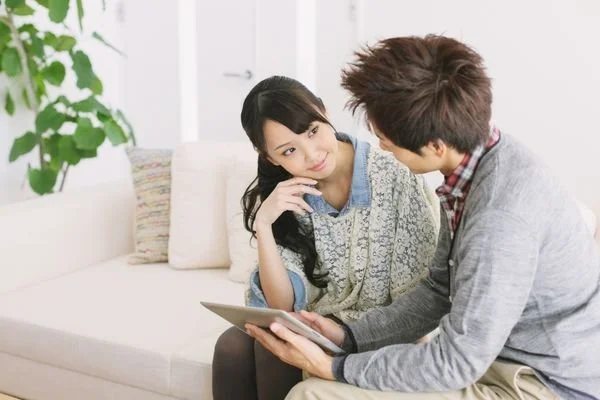 A couple reviewing a premarital assessment together on a tablet at home.