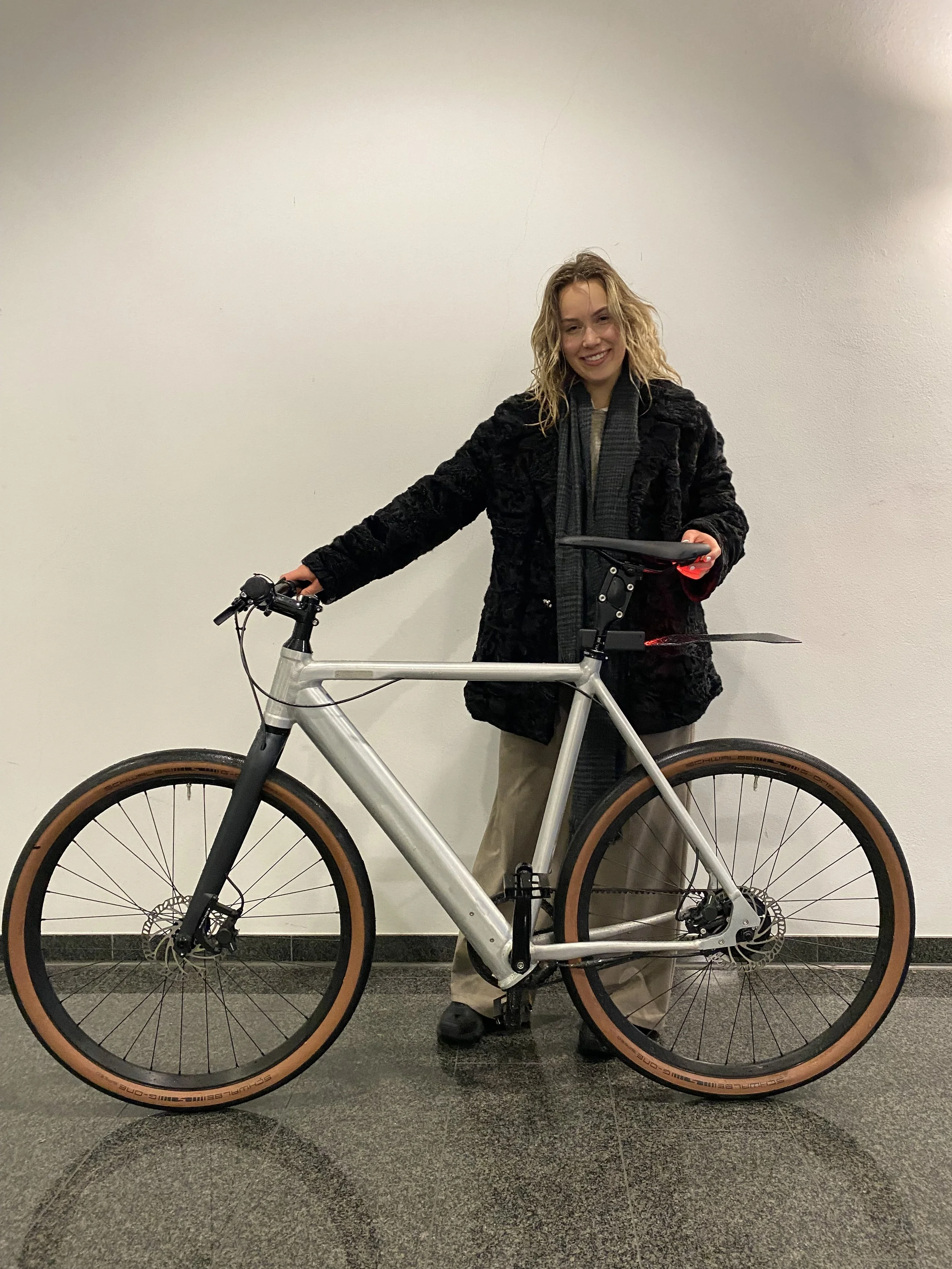 Person posing with a bicycle indoors