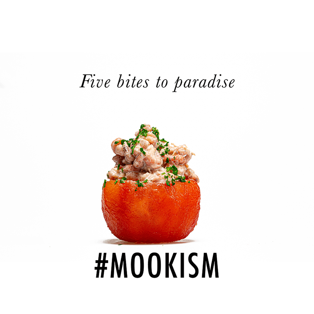 A stuffed tomato with a grainy filling topped with chopped herbs, with the text 'Five bites to paradise' above and '#MOOKISM' below.